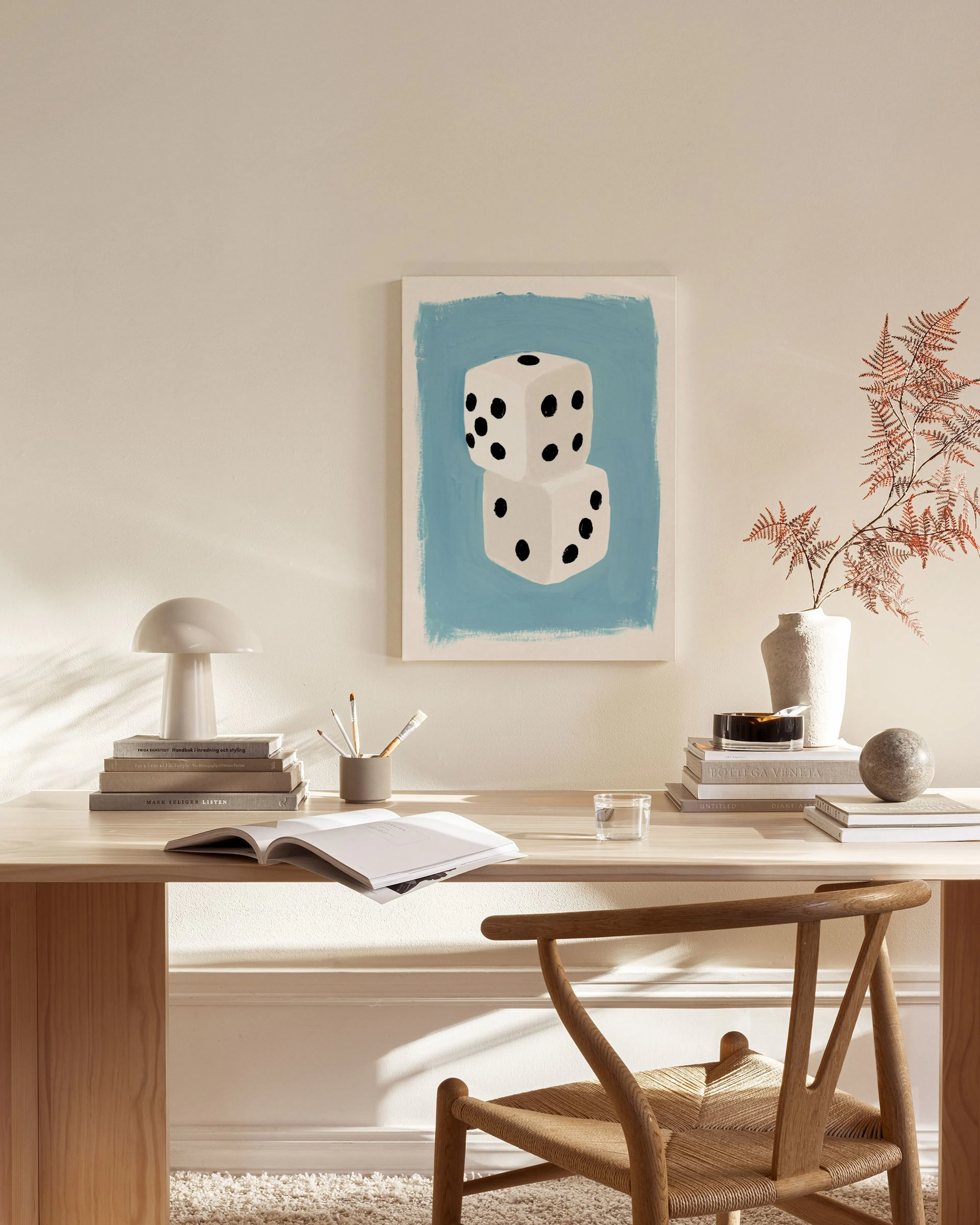 Toile de dés blancs avec des points noirs sur fond bleu, accrochée dans un salon moderne.