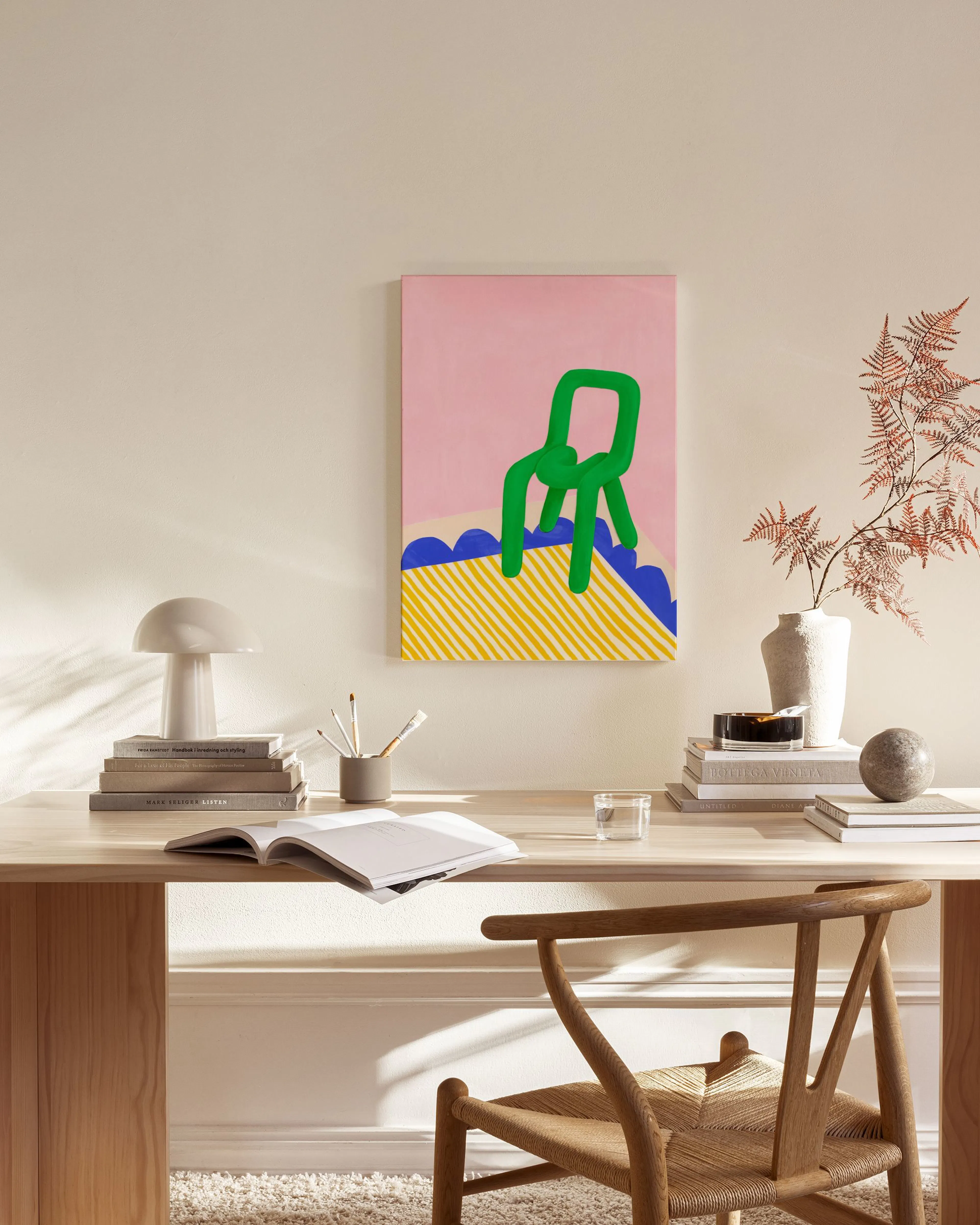 Toile rose avec une chaise verte et des vagues bleues sur un fond jaune à rayures, accrochée dans un salon moderne.