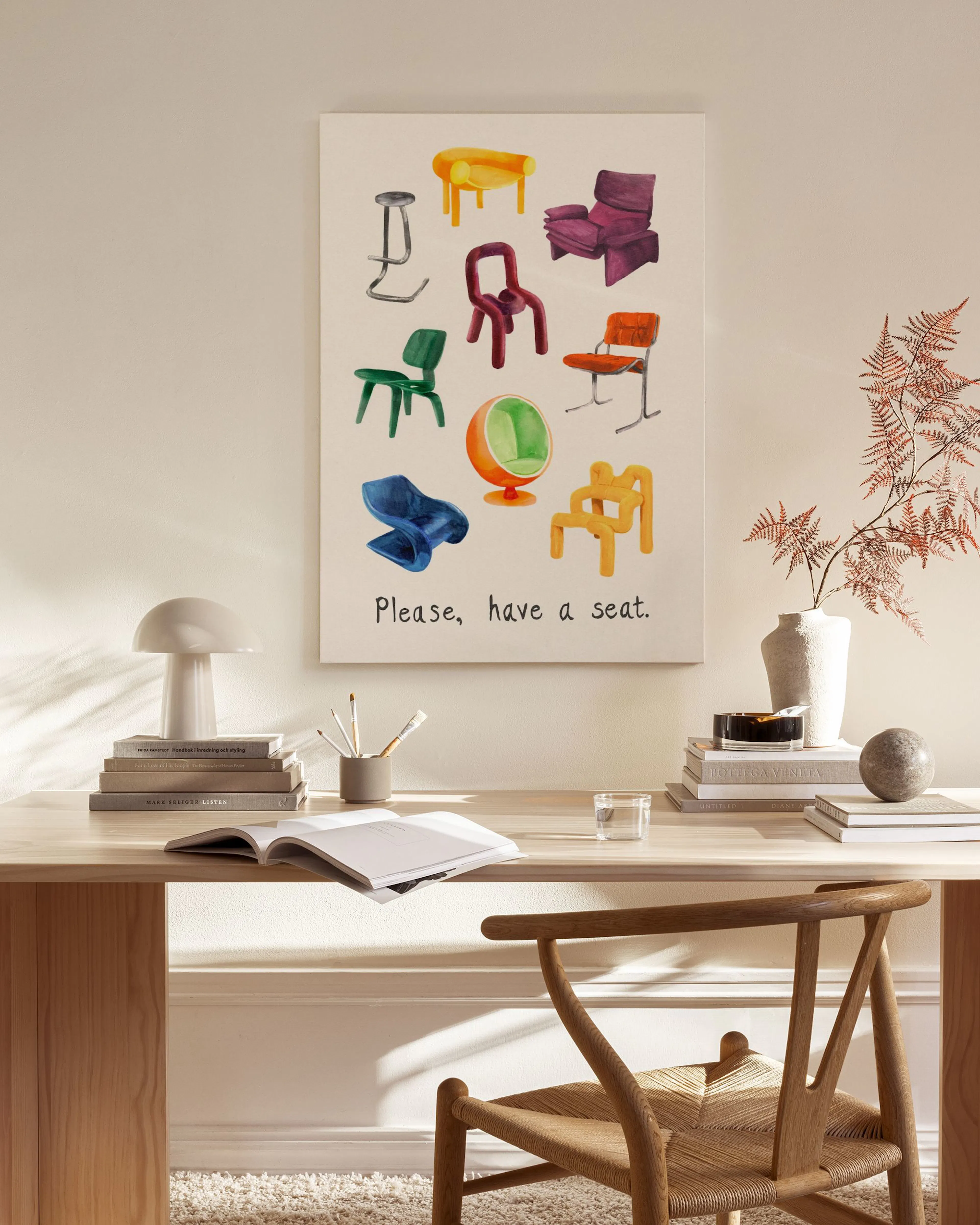 A canvas print of colourful chairs in various designs, with Please, have a seat text, hanging in a bright modern living room.