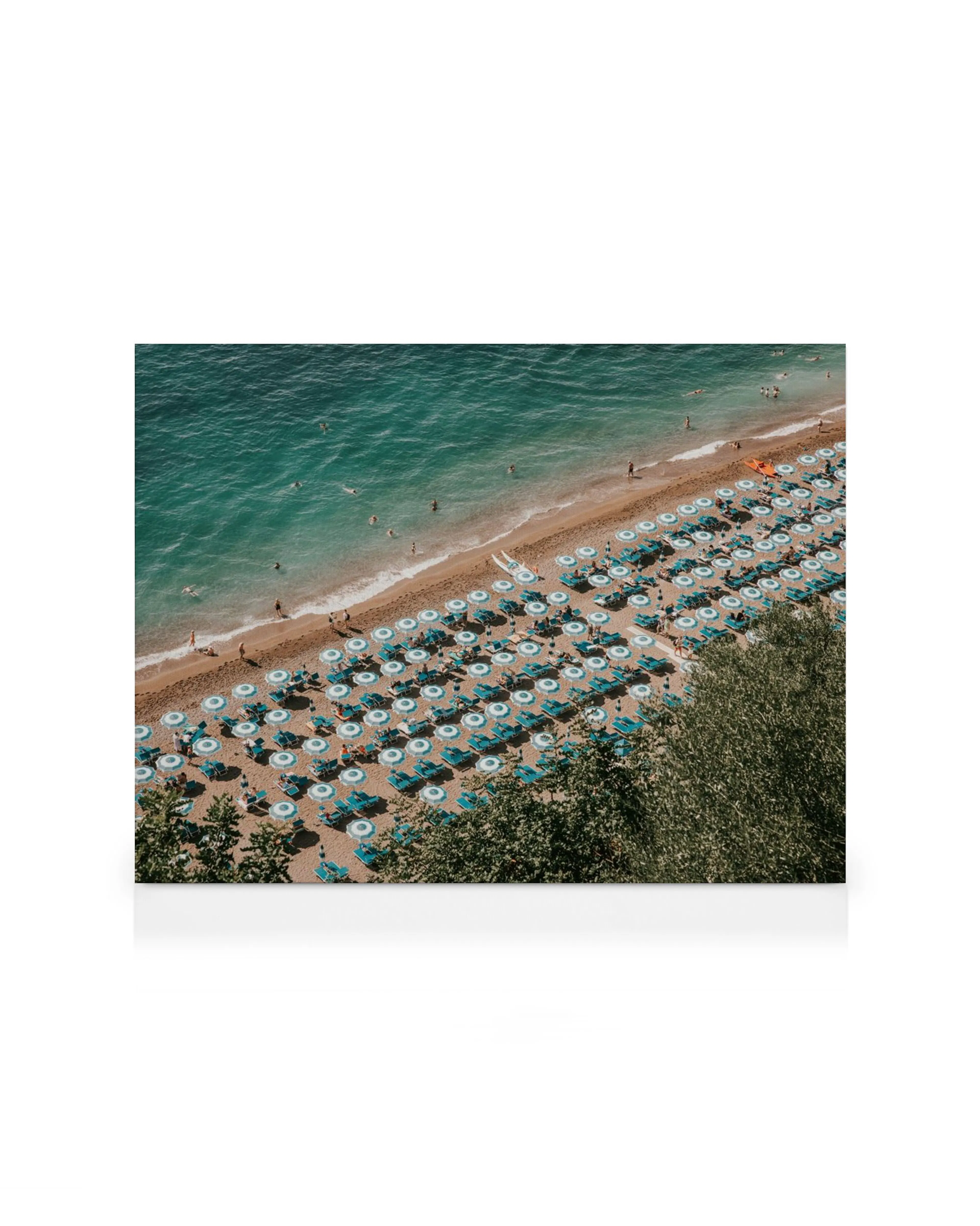 Luftfoto af Positano strand med turkise parasoller og liggestole, mennesker bader i det azurblå hav.
