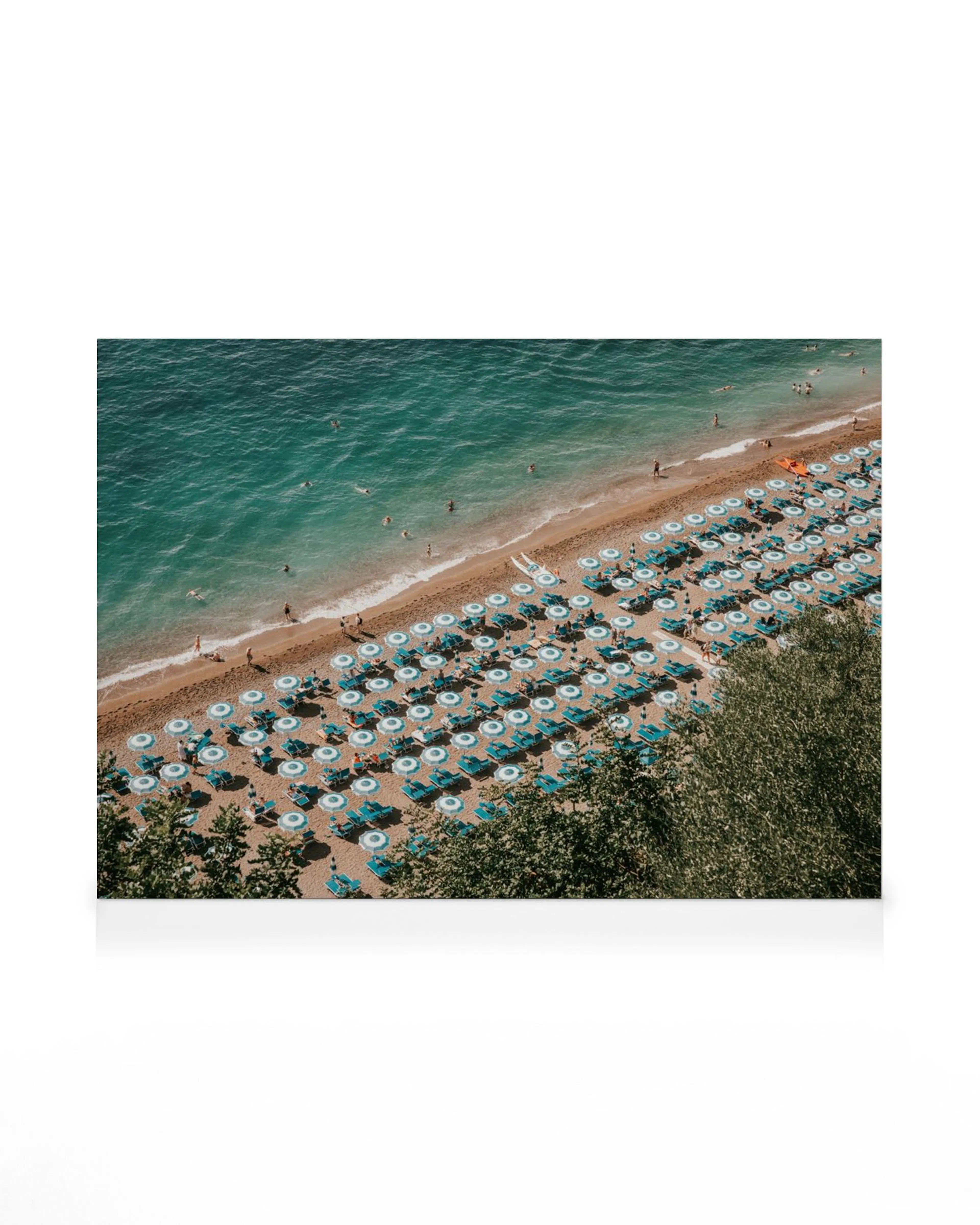 Lienzo de la playa de Positano con sombrillas y tumbonas azules, mar turquesa y bañistas.