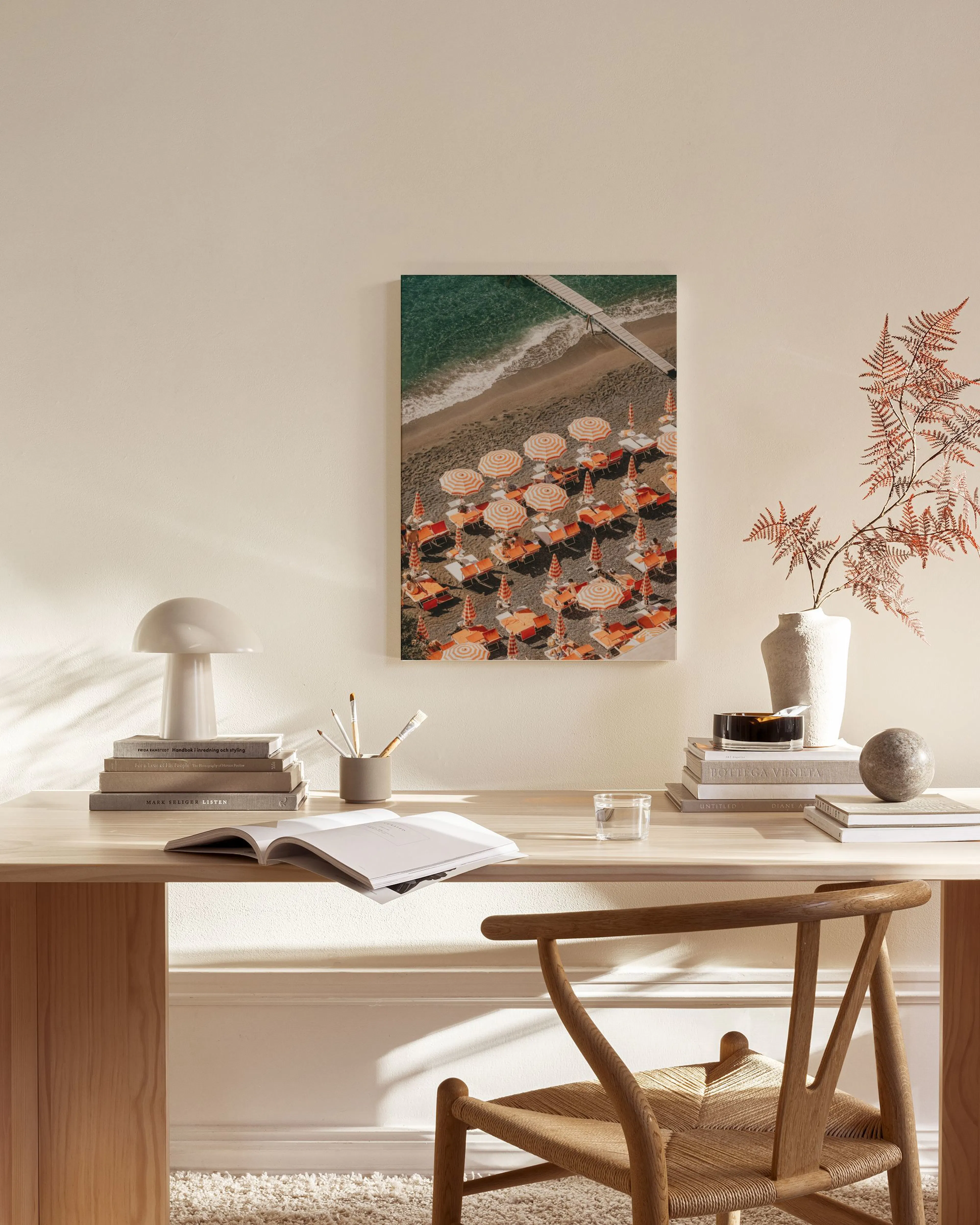 Leinwandbild einer Strandansicht von oben mit Sonnenschirmen, aufgehängt in einem modernen Wohnzimmer.