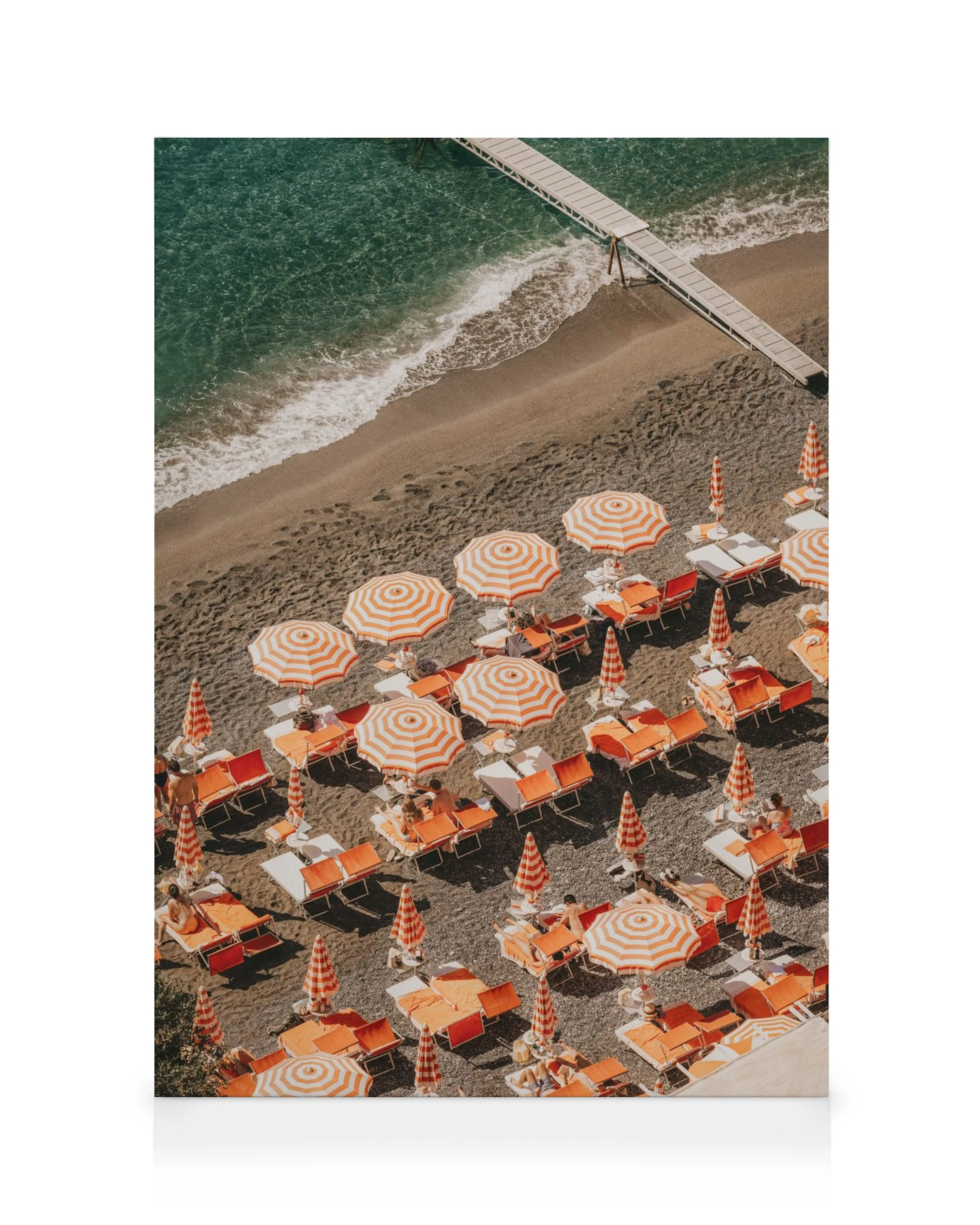 Pomarańczowo-białe parasole i leżaki na piaszczystej plaży, z drewnianym molo i turkusowym morzem.