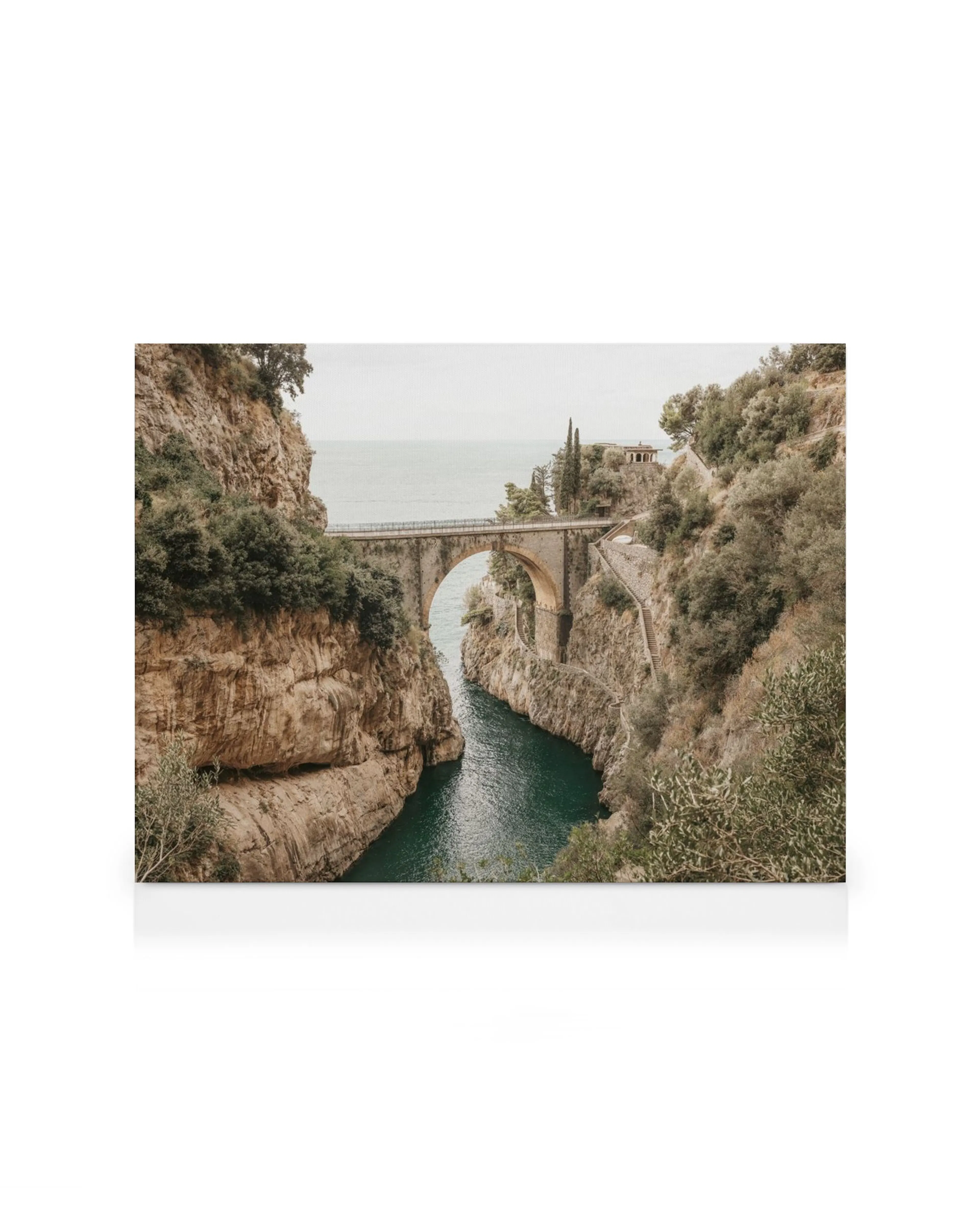 Fiordo di Furore bridge over a narrow fjord with turquoise water, rocky cliffs, and green foliage, Italy scenic view.