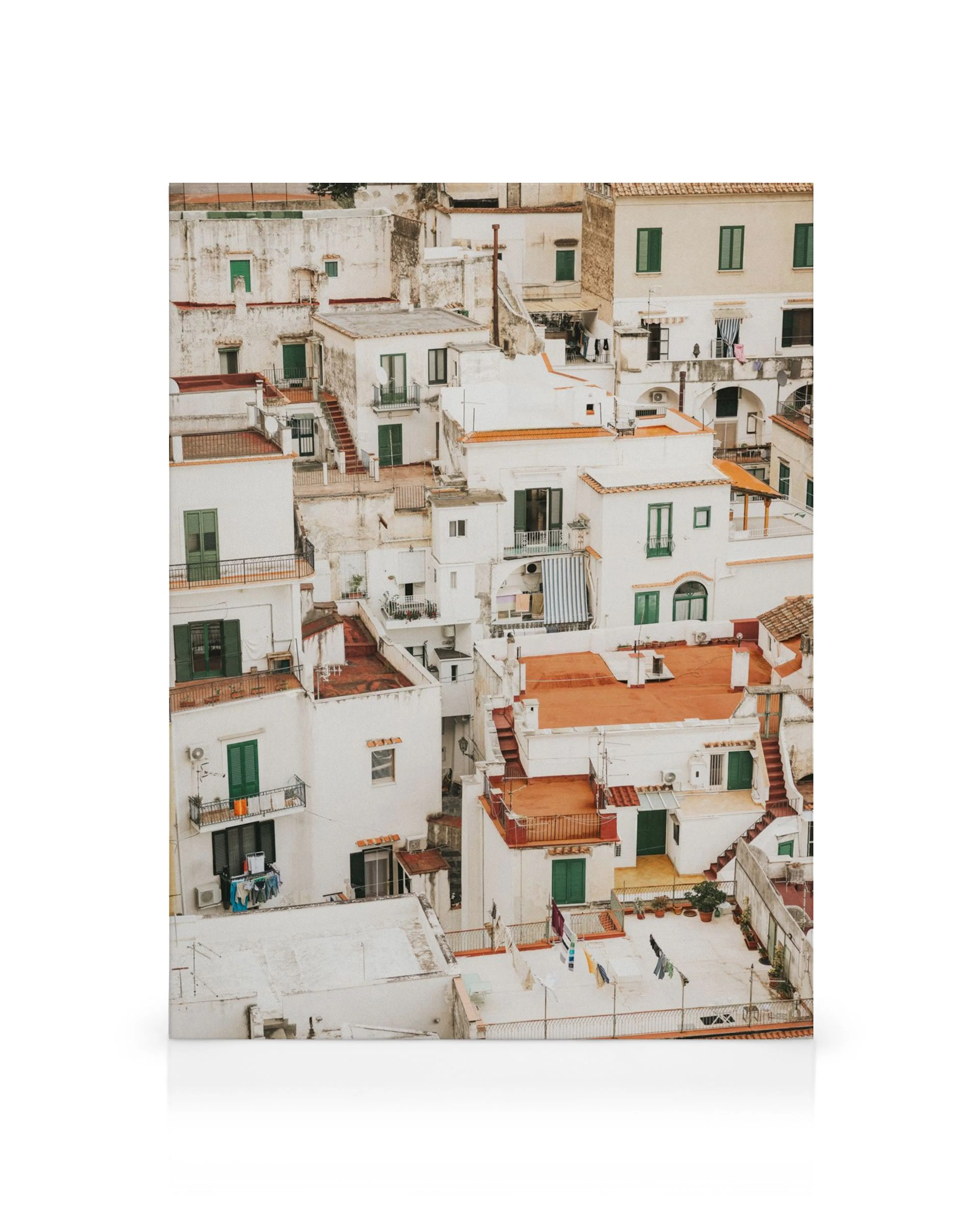 Vitkalkade hus i Amalfi med terrakottafärgade tak och gröna fönsterluckor. Detaljerade balkonger och tvättlinor.
