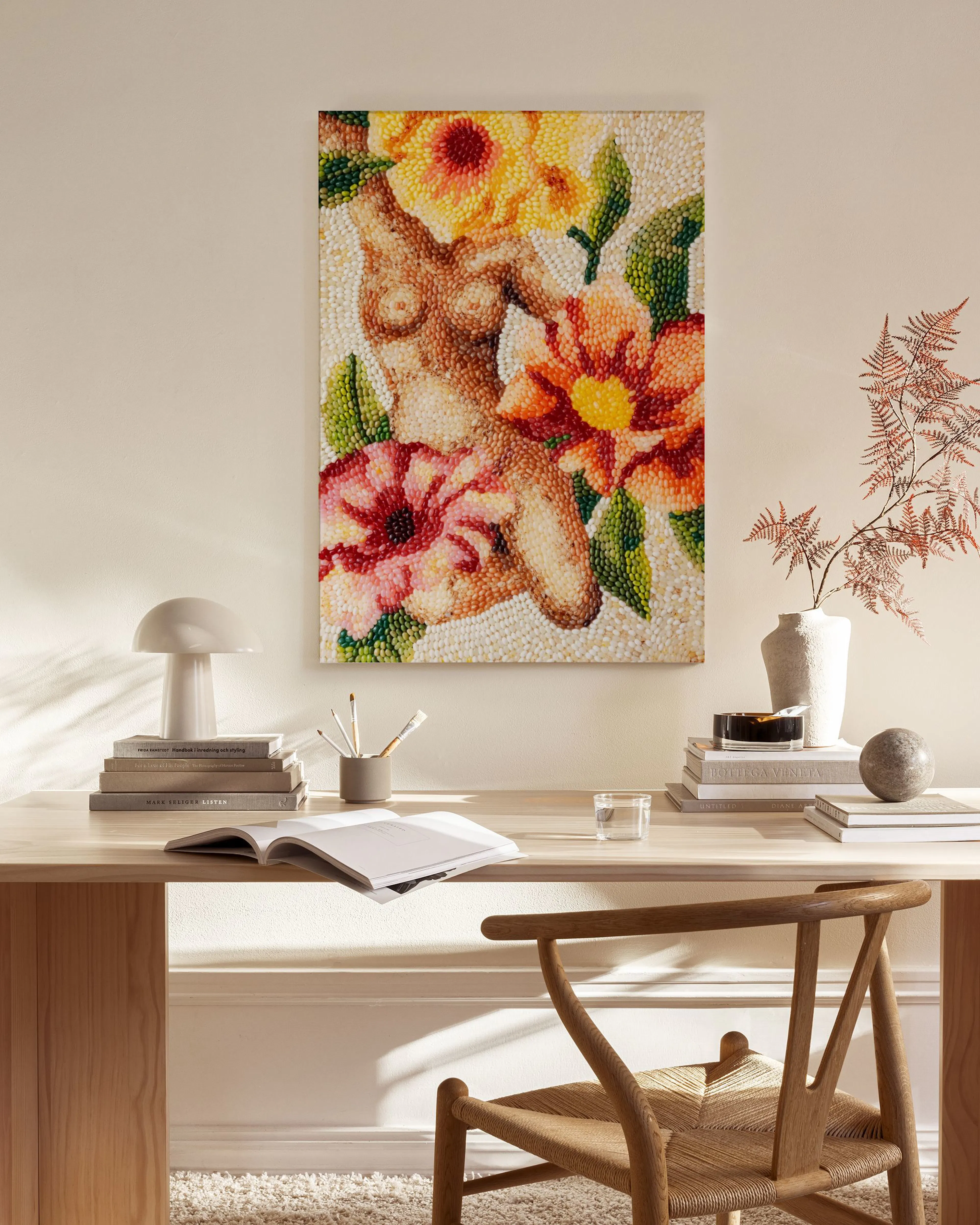 Lerretsbilde av kvinnekropp med blomster i mosaikkstil, henger i en moderne stue over en benk.