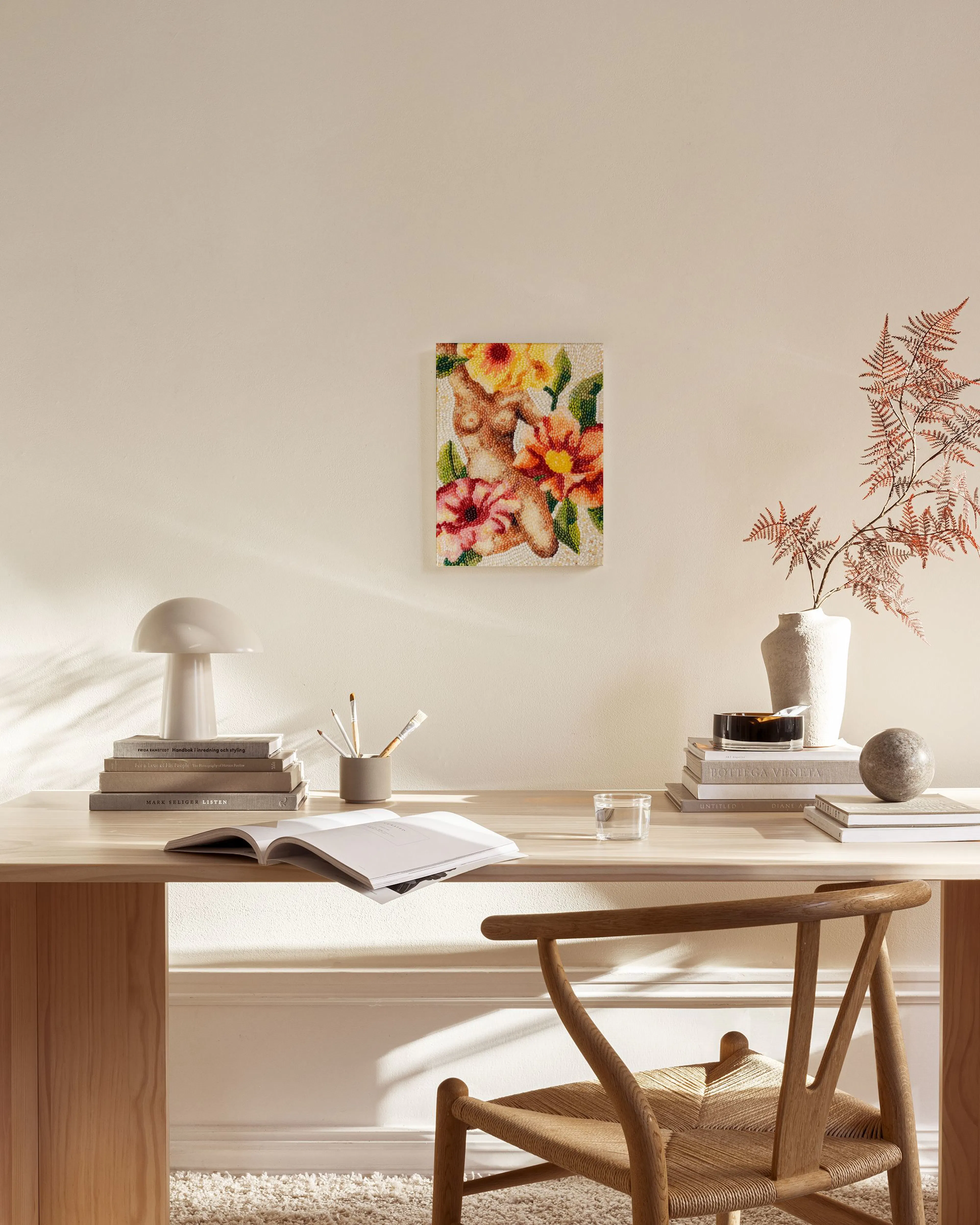 Toile murale mosaïque dun torse féminin entouré de fleurs jaunes et orangées, accrochée dans un salon moderne.