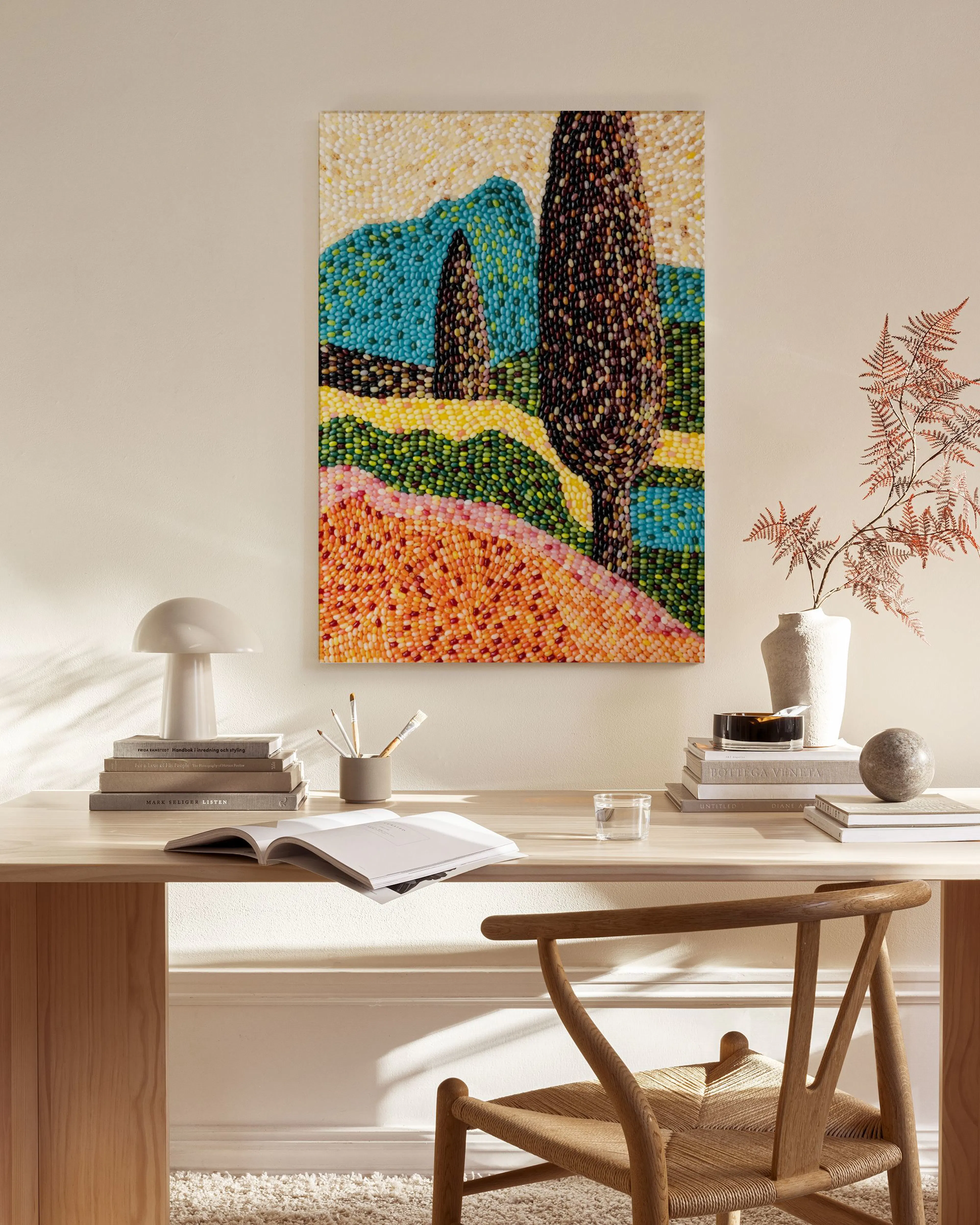 Leinwandbild mit Landschaft in Punktmalerei, mit Hügeln und Bäumen, über einem Sideboard im Wohnzimmer.