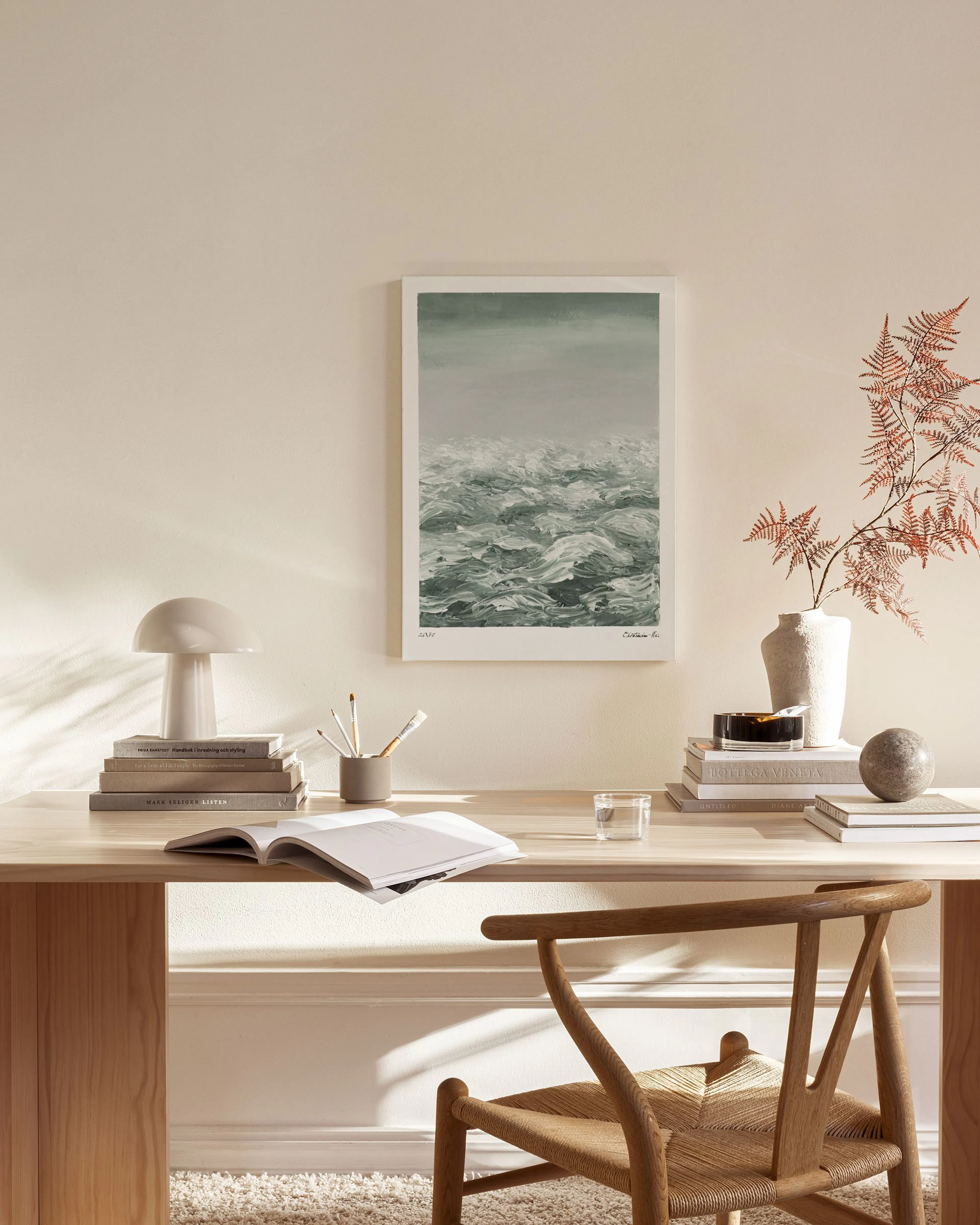 A canvas print depicting a stormy sea with dark green and white waves, hanging in a modern living room.
