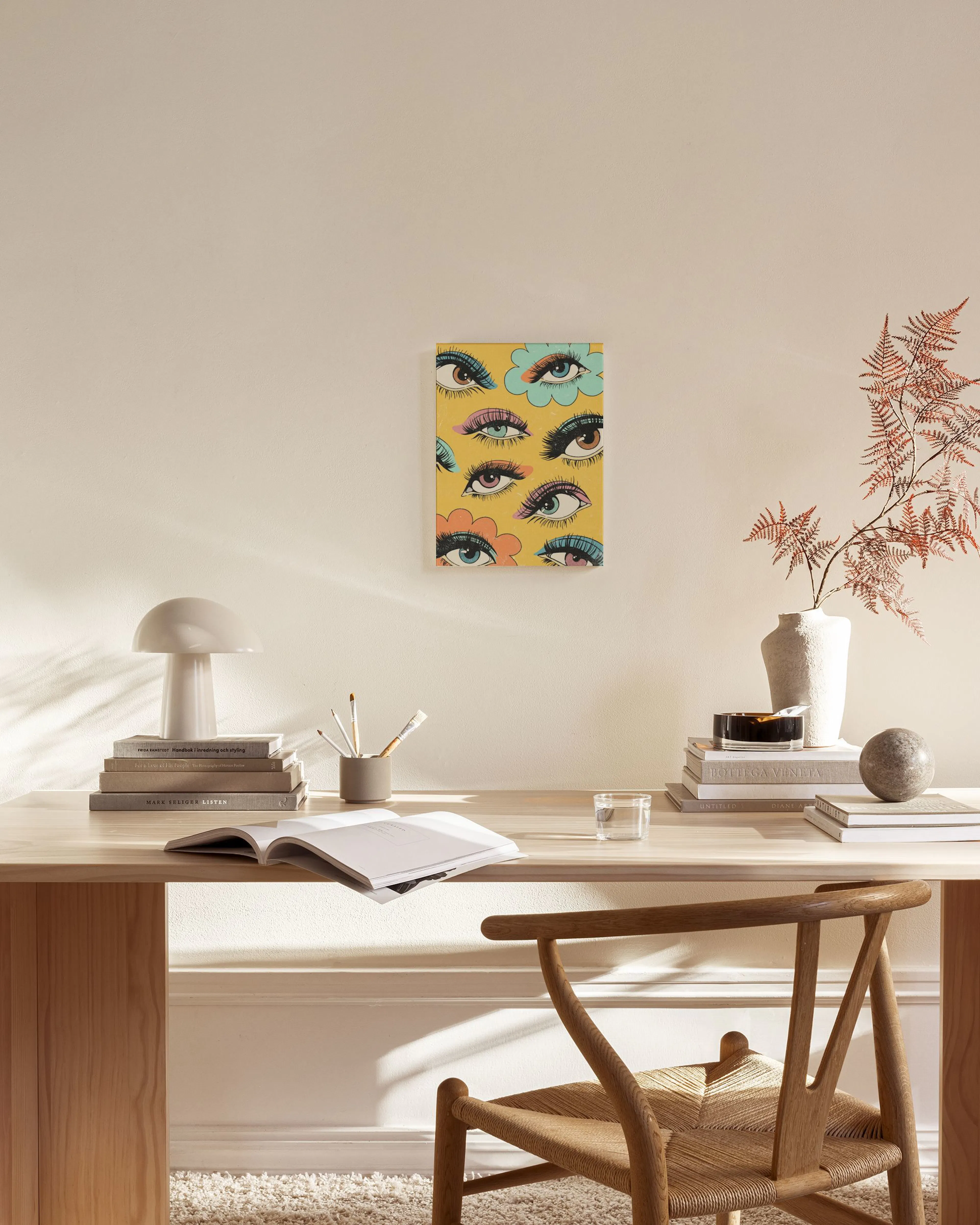 Pop art style print with colorful eyes on a yellow background, displayed in a modern living room.
