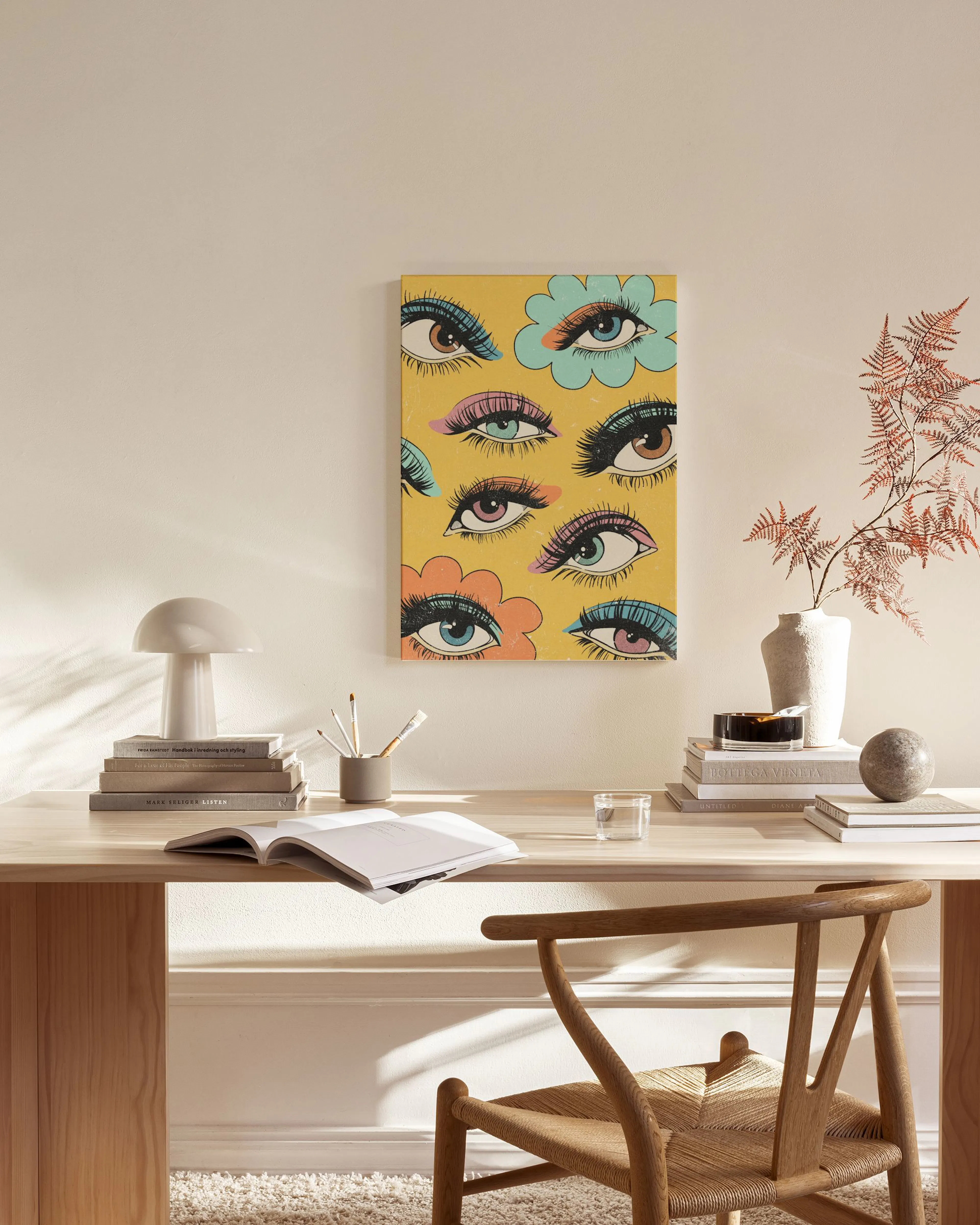 Pop art canvas print of multiple eyes with colourful eyeshadow and long lashes on a yellow background, in a modern living room.