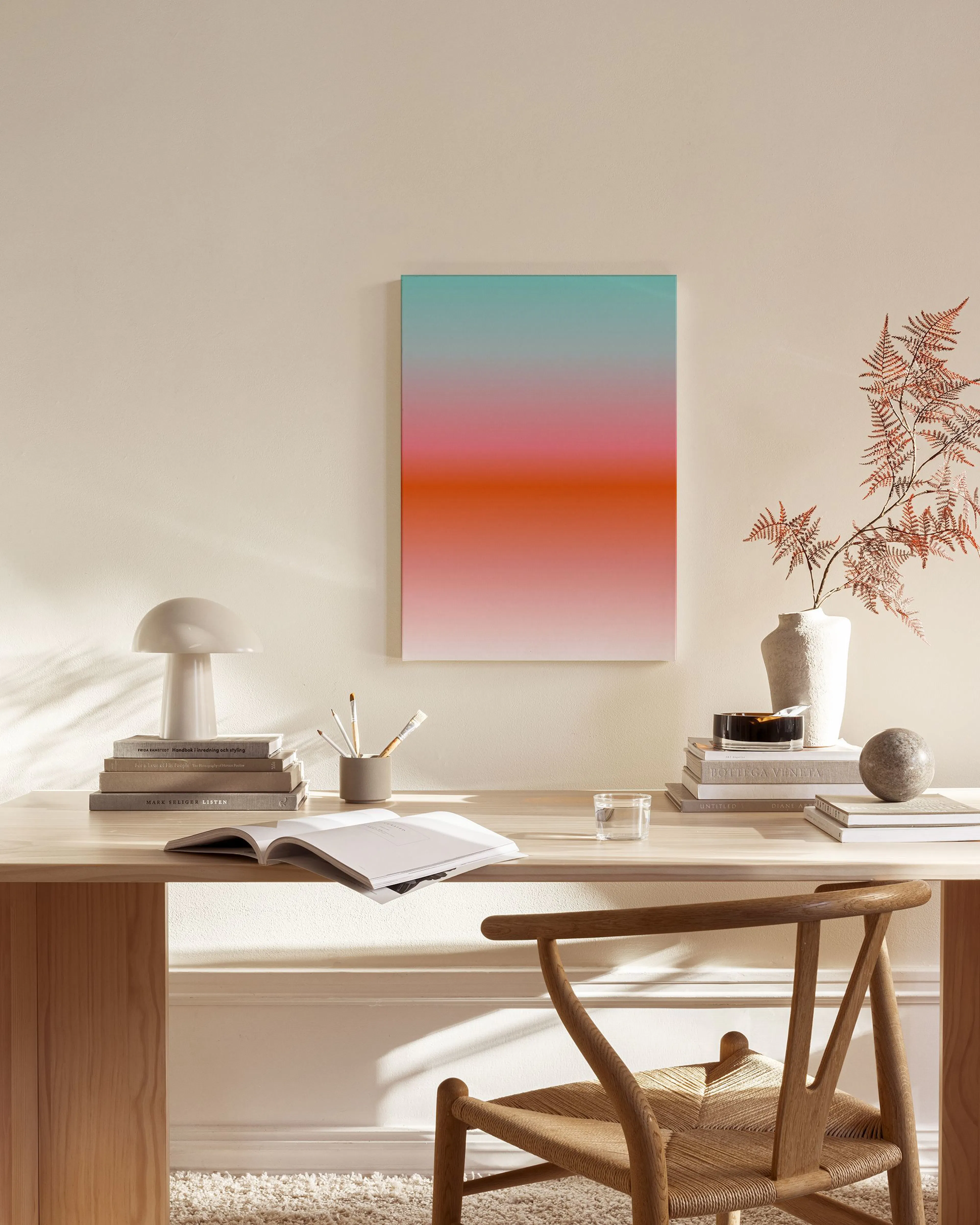 A canvas print with a vibrant gradient from teal to pink to orange, displayed in a modern living room.