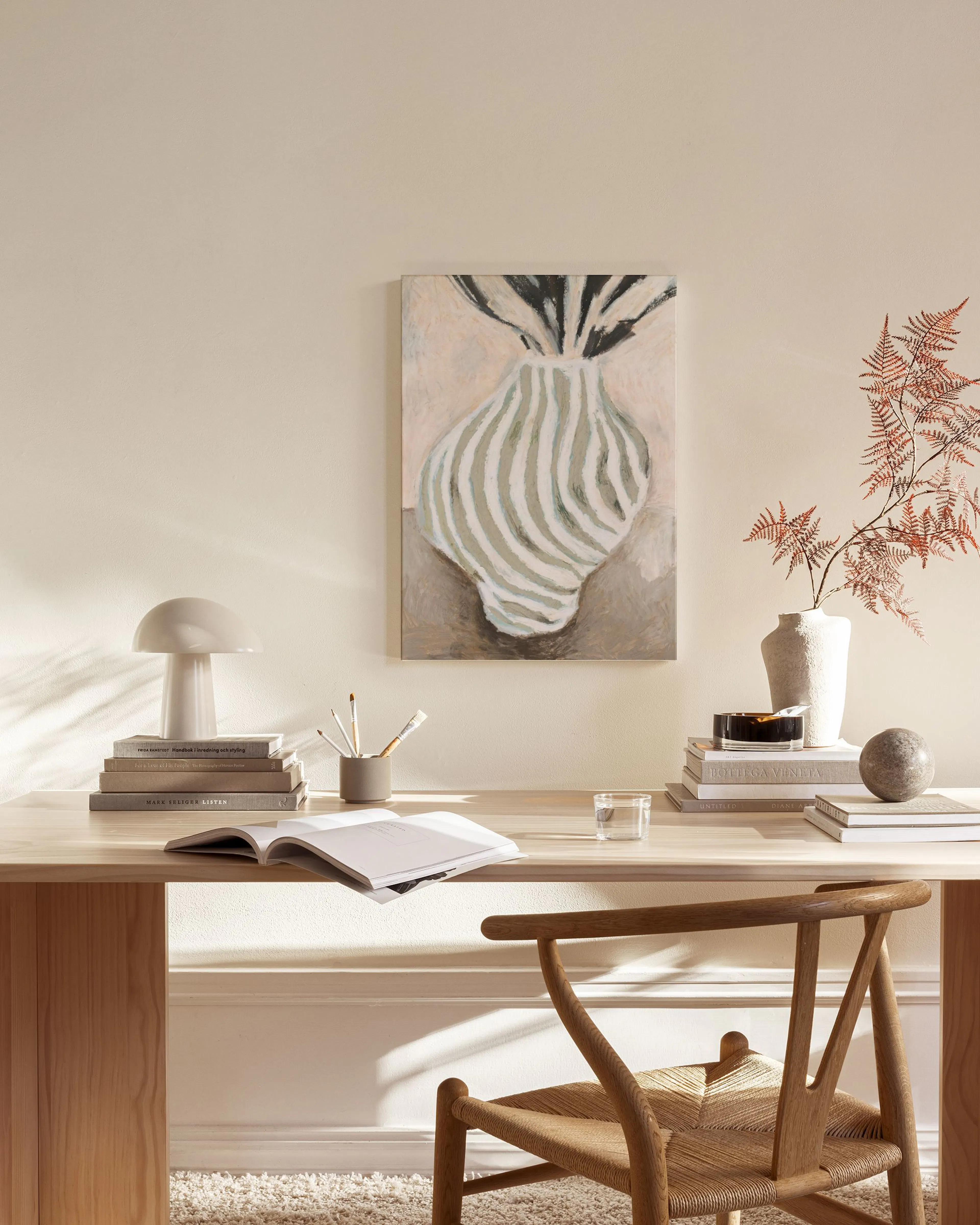Canvas met abstracte vaas met grijsgroene en witte strepen, hangend in een neutrale woonkamer boven een houten dressoir.