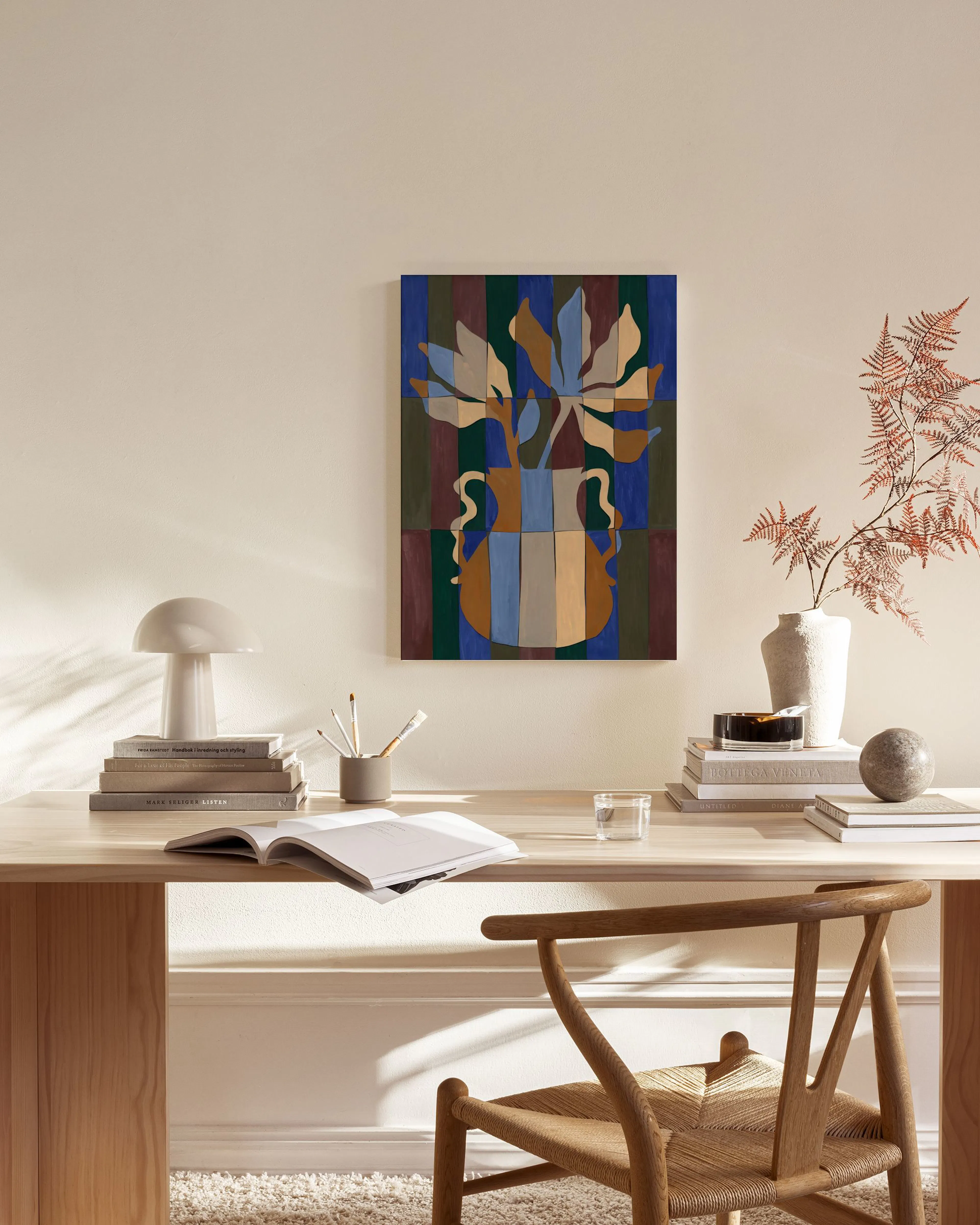 Stampa su tela con vaso astratto e fiori stilizzati su sfondo a strisce, appesa in un soggiorno moderno.