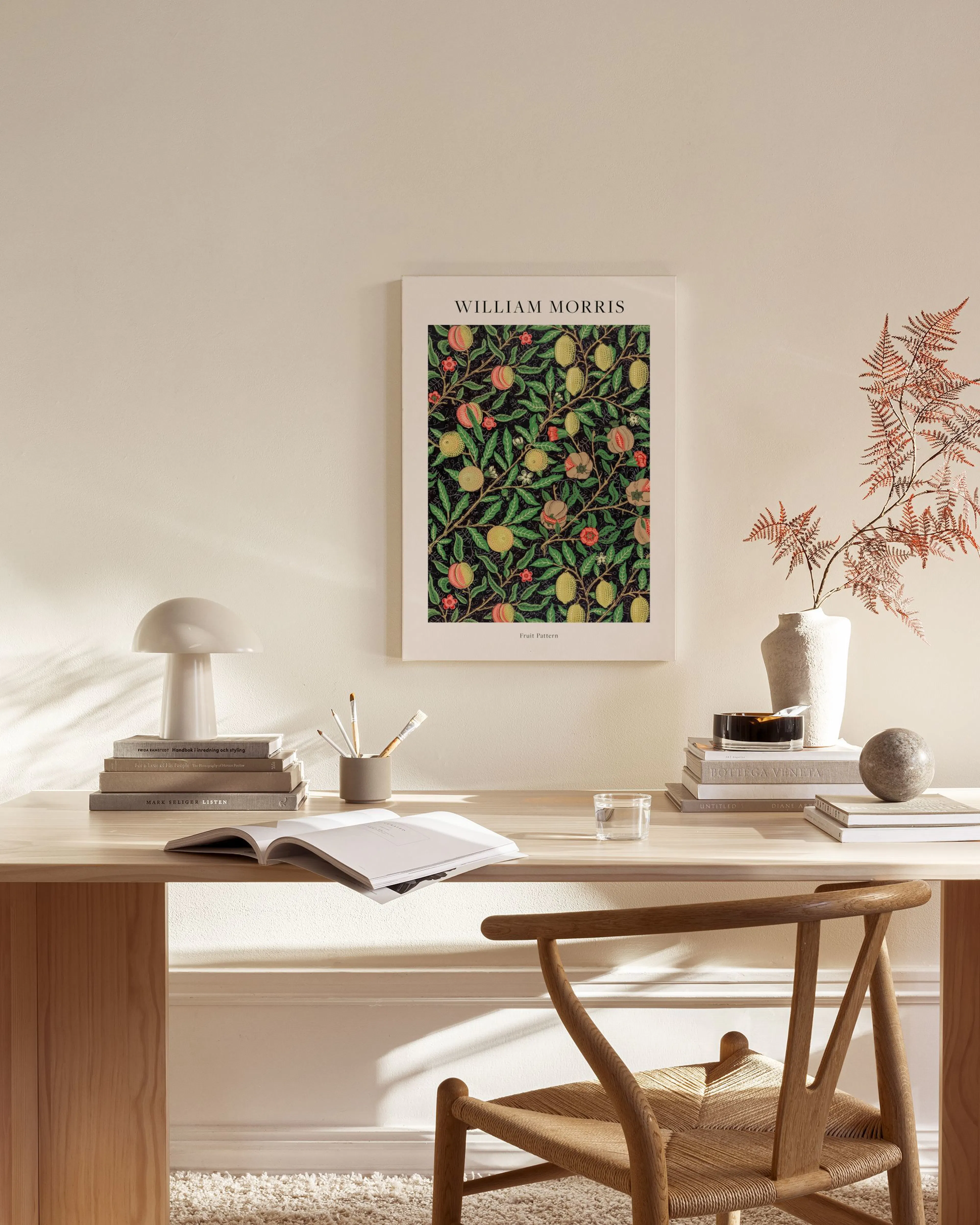 Stampa su tela William Morris con frutta e foglie, appesa sopra una credenza in un salotto moderno.