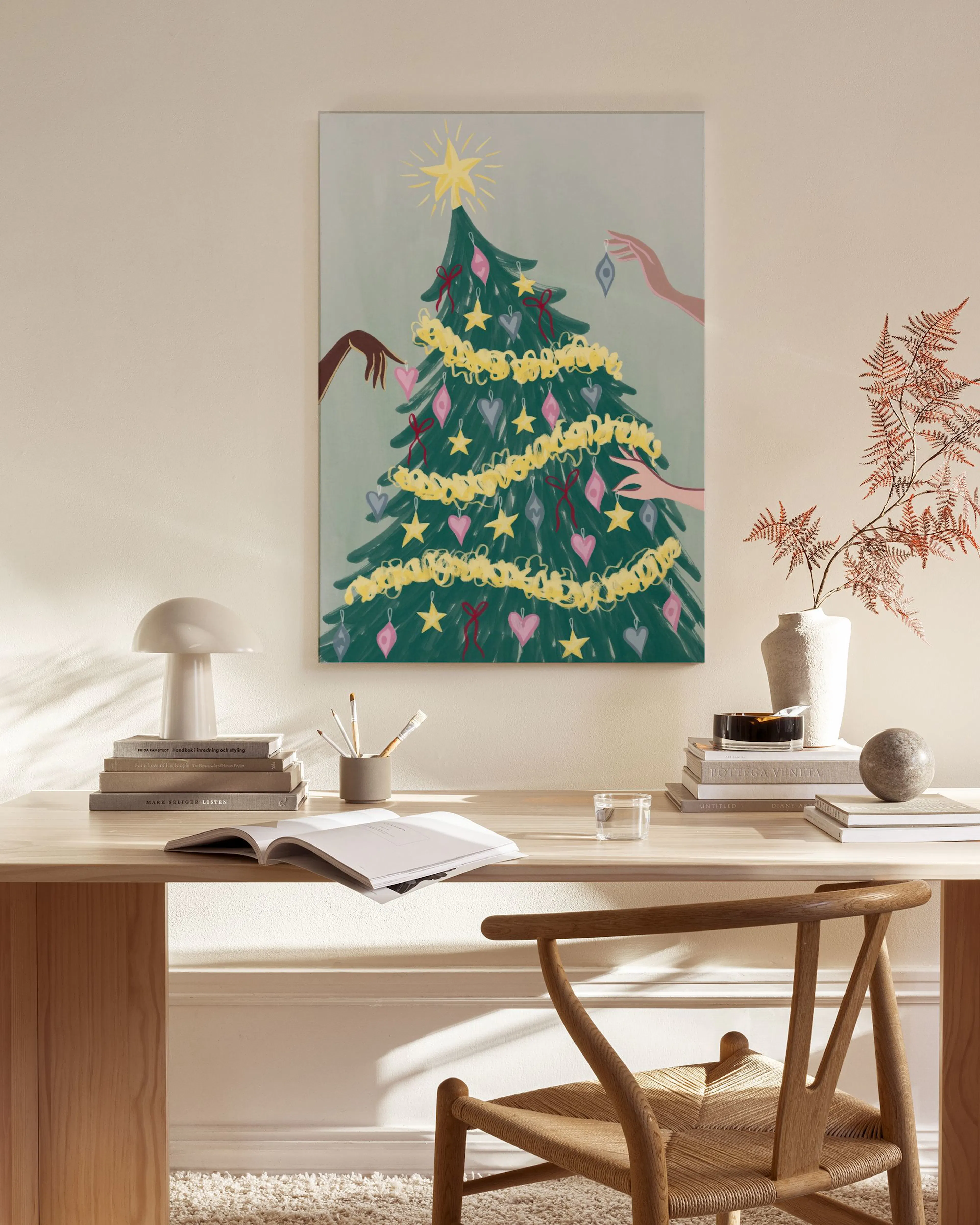 Lienzo de un árbol de Navidad con manos decorándolo, colgado en una sala de estar moderna sobre una mesa de madera.