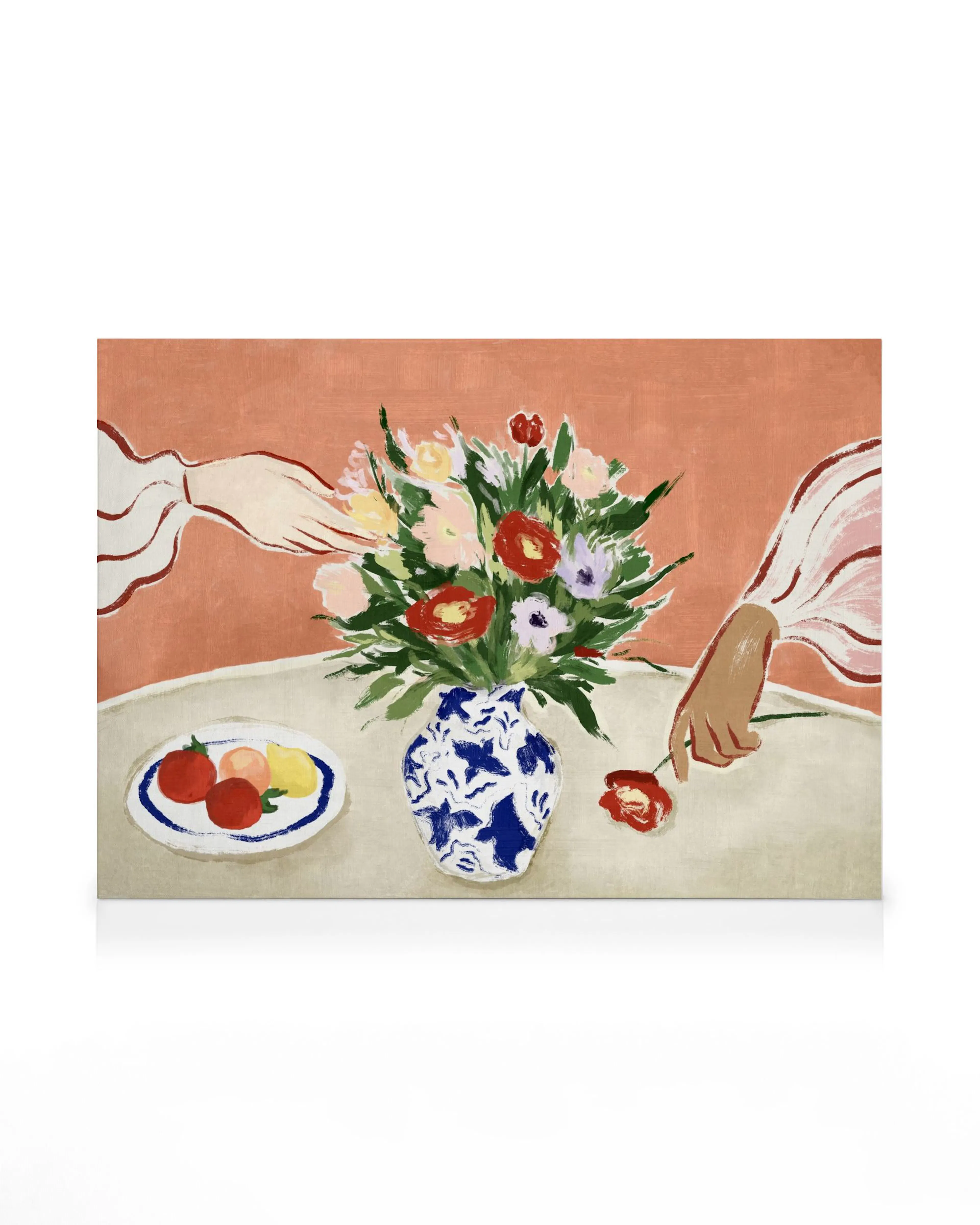 Colourful floral canvas print with a bouquet in a blue vase, fruit, and two hands on a table.