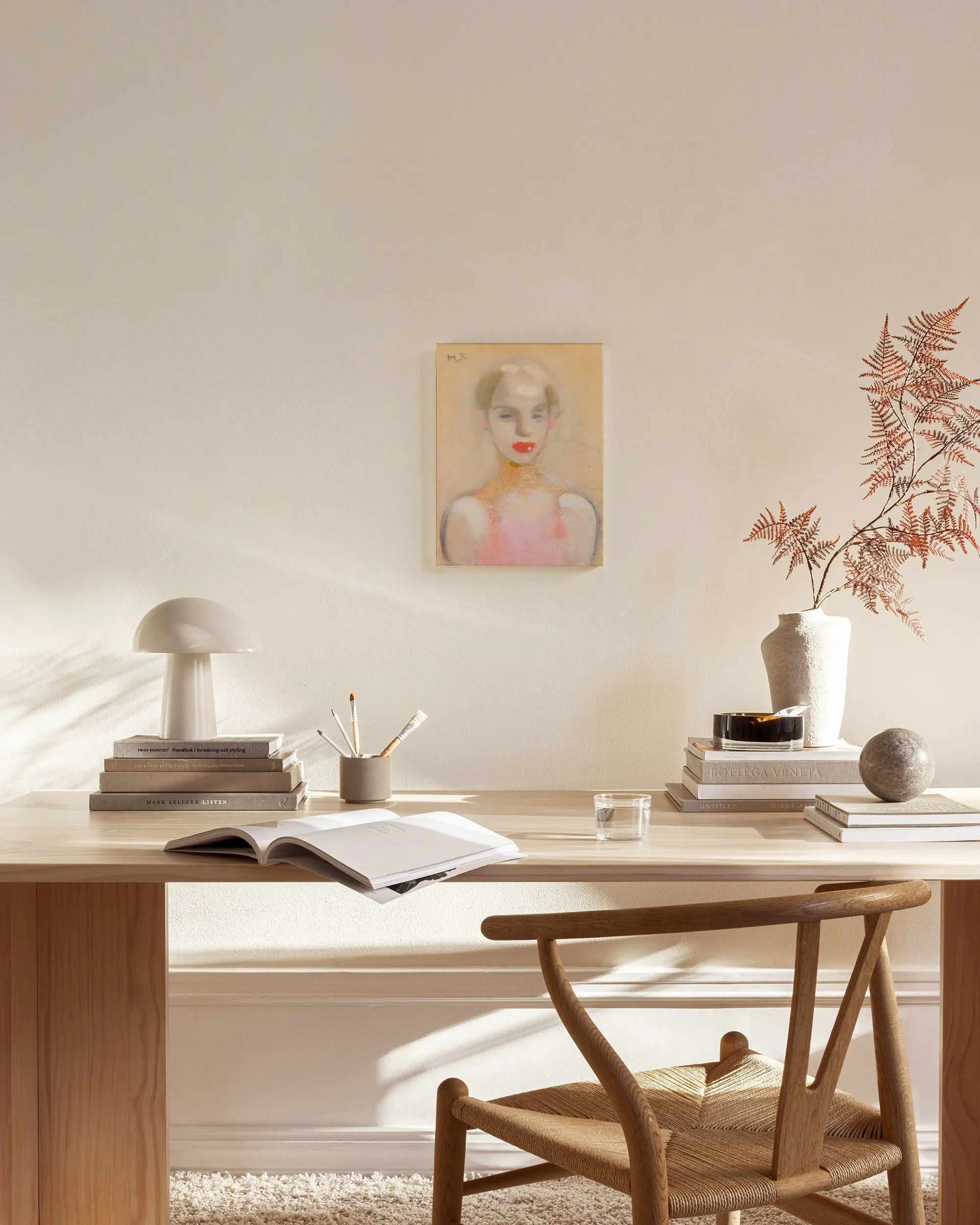 Lienzo de una mujer con cabello rubio y labios rojos, colgando en una sala de estar moderna con muebles de madera.