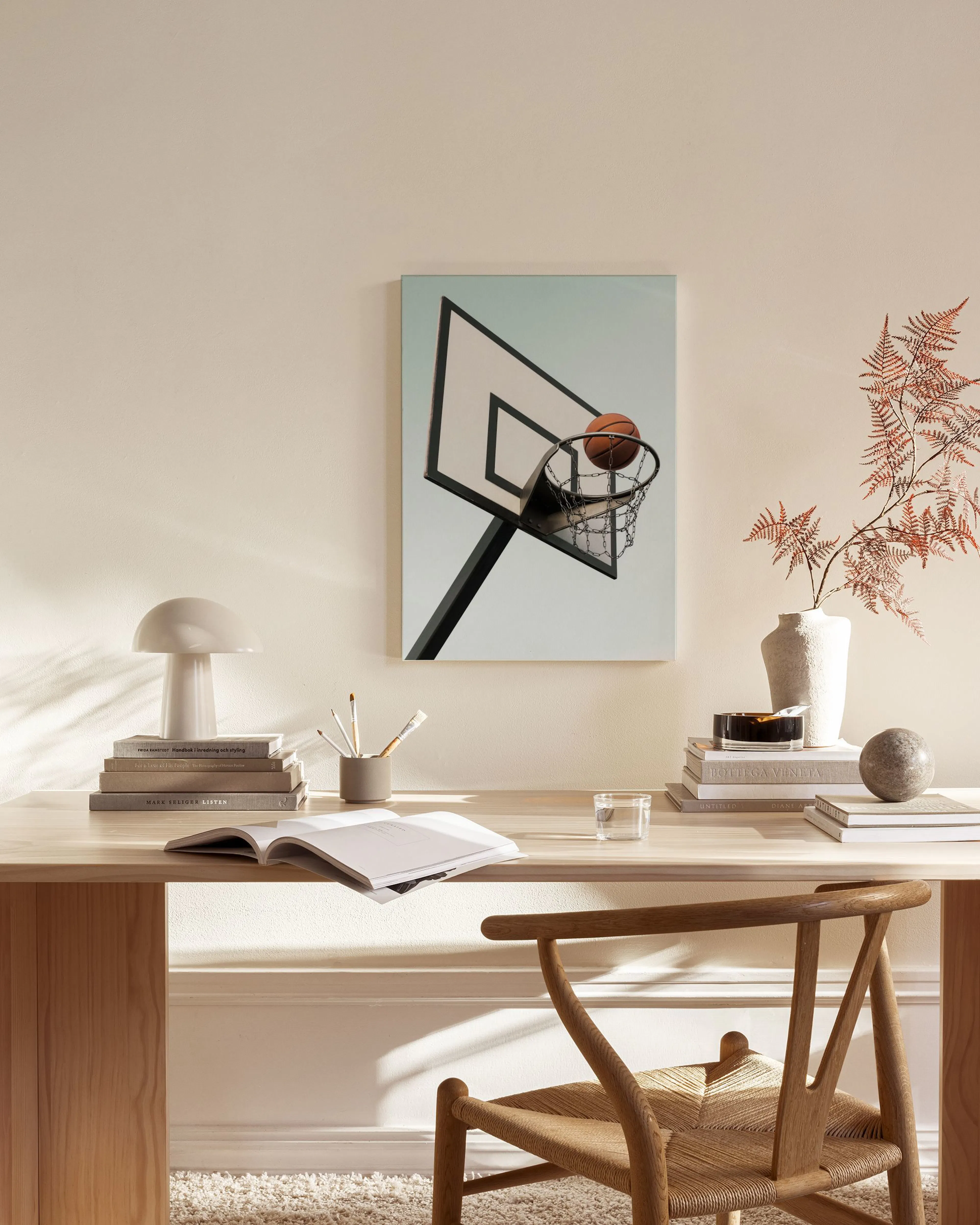Canvas van een basketbalring met bal tegen een blauwe lucht, hangend in een modern interieur.
