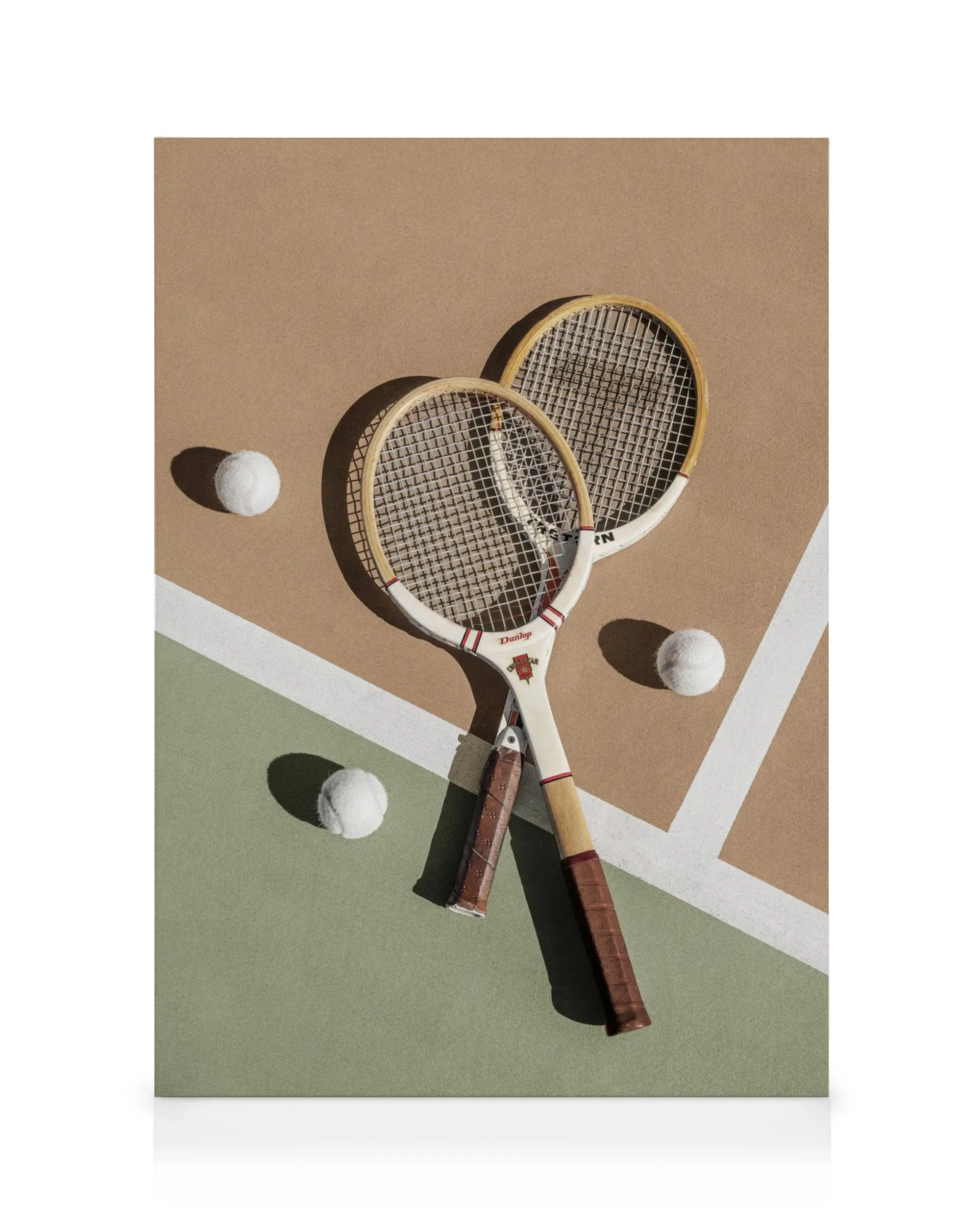 Due racchette da tennis vintage incrociate con palline bianche su campo verde e marrone, stampa su tela.