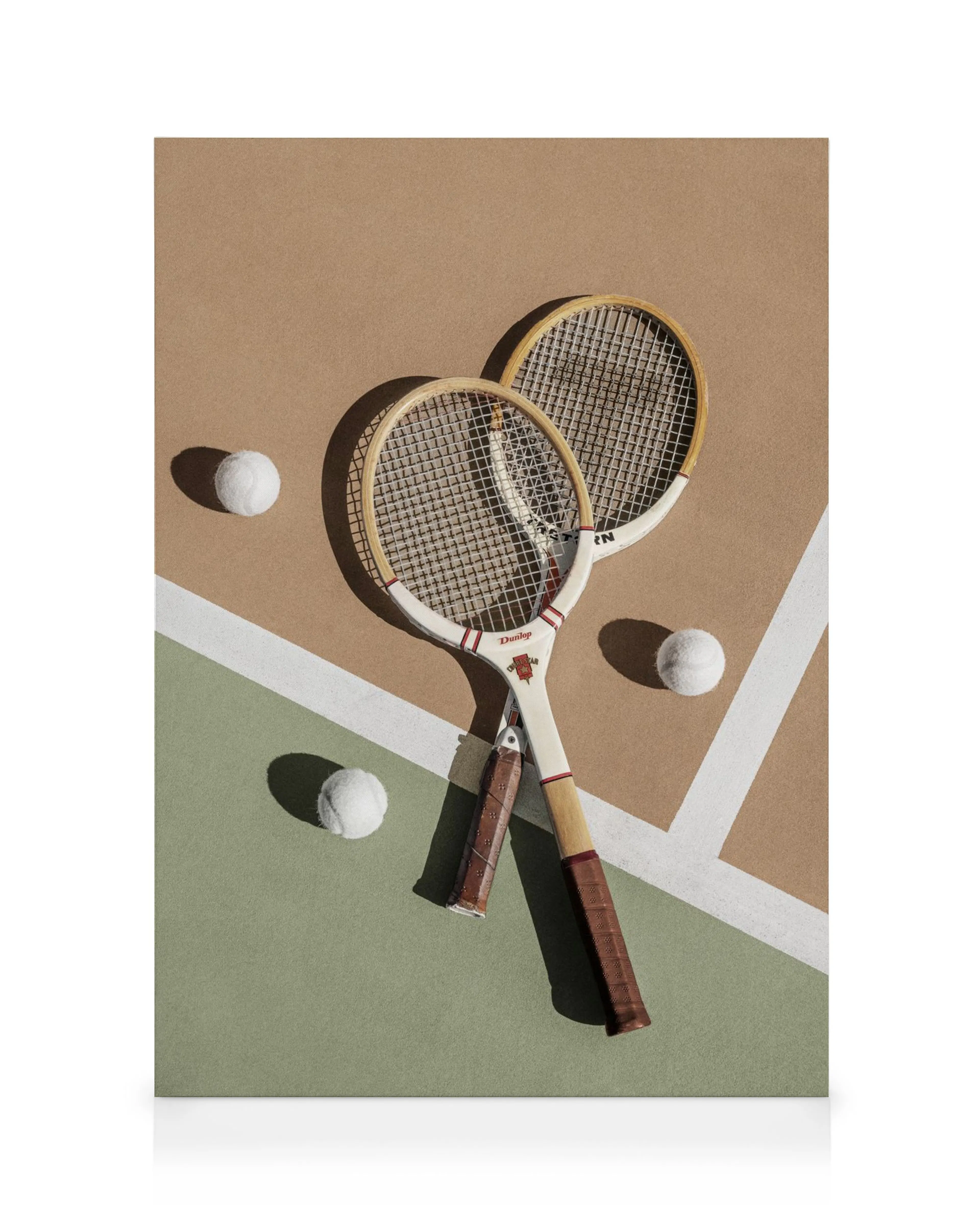 Due racchette da tennis vintage incrociate con palline bianche su campo verde e marrone, stampa su tela.