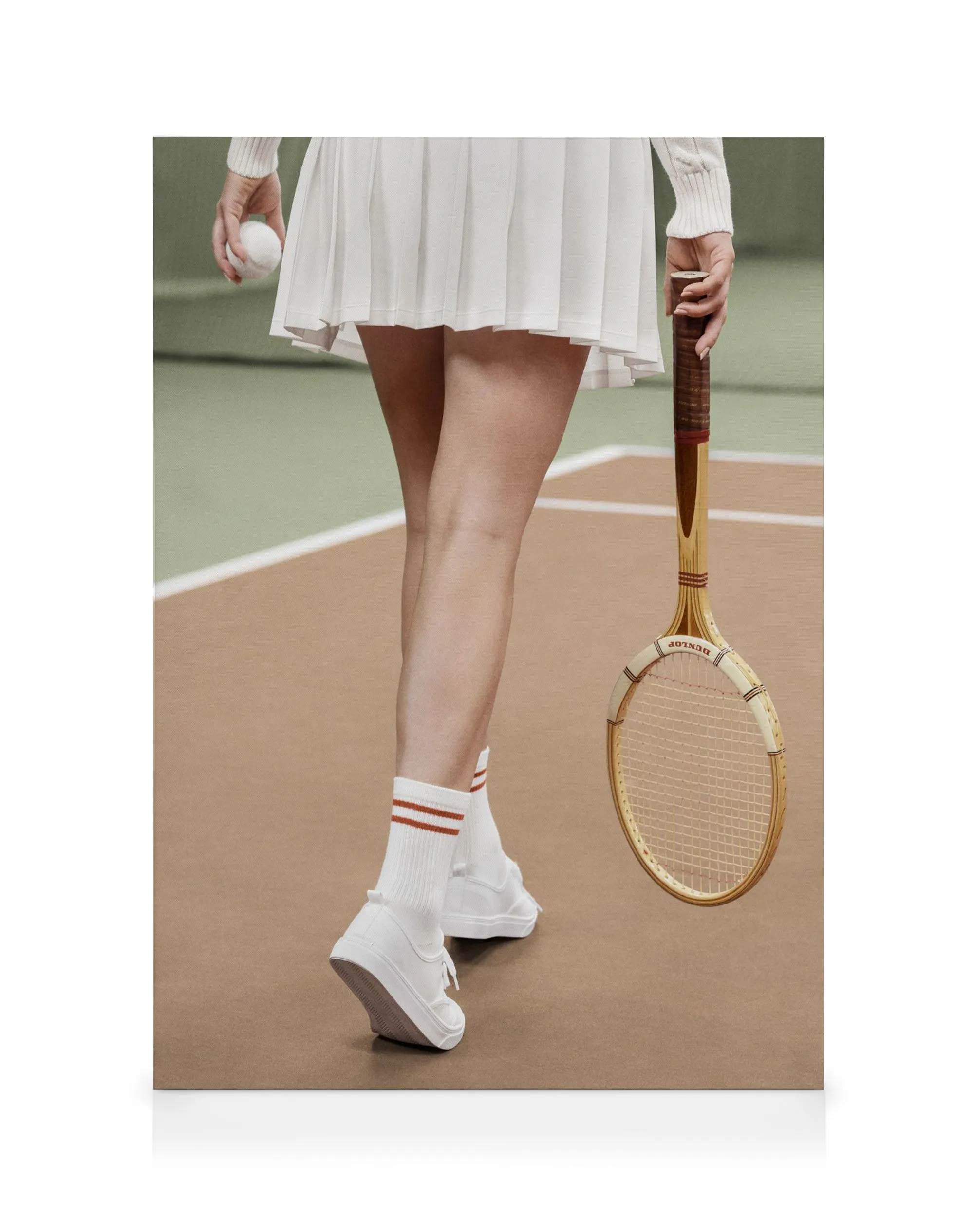 A tennis player in a white skirt holding a racquet and ball on a clay court canvas print.