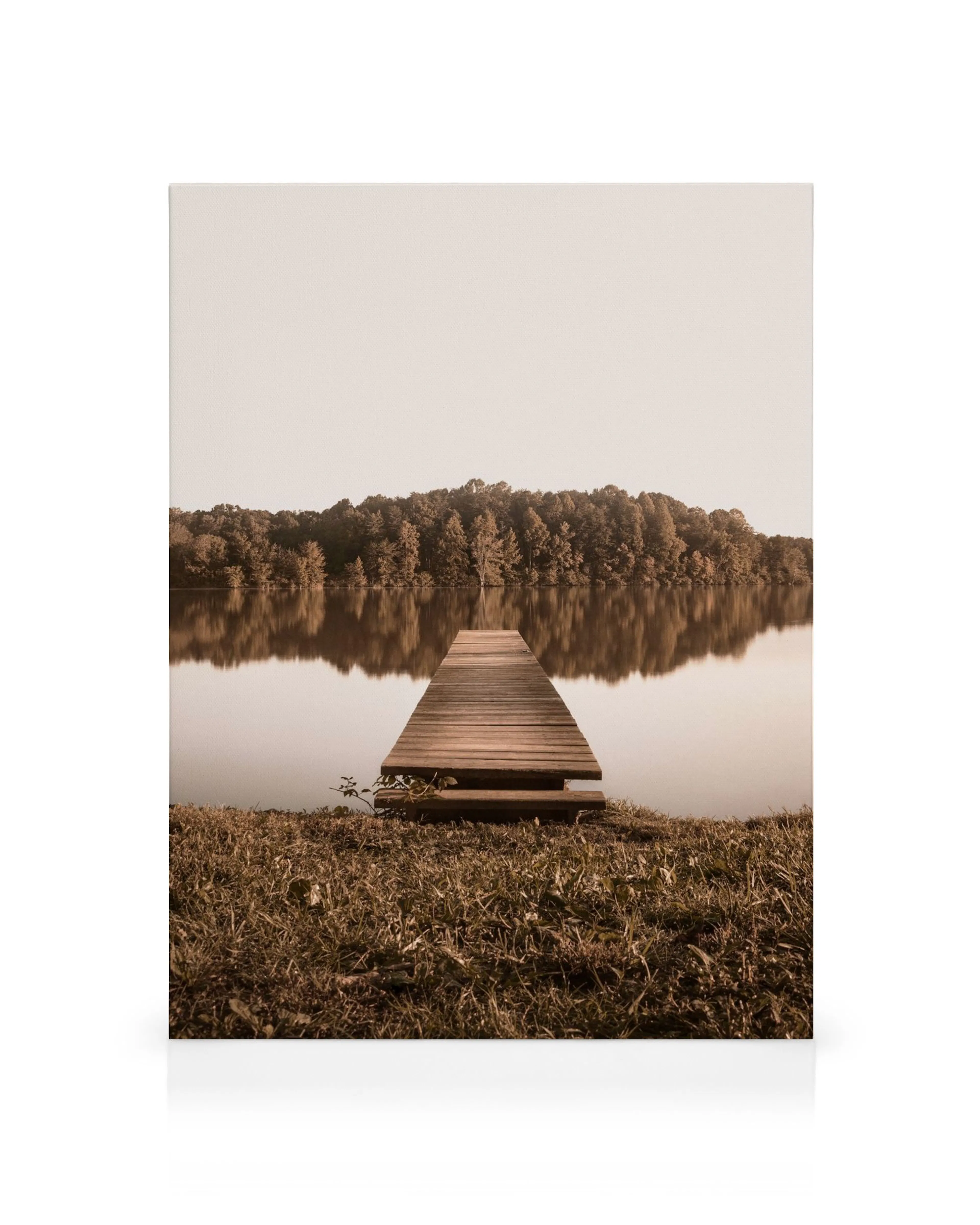 Wooden dock on a calm lake with reflections of trees on the water, sepia tone canvas print.