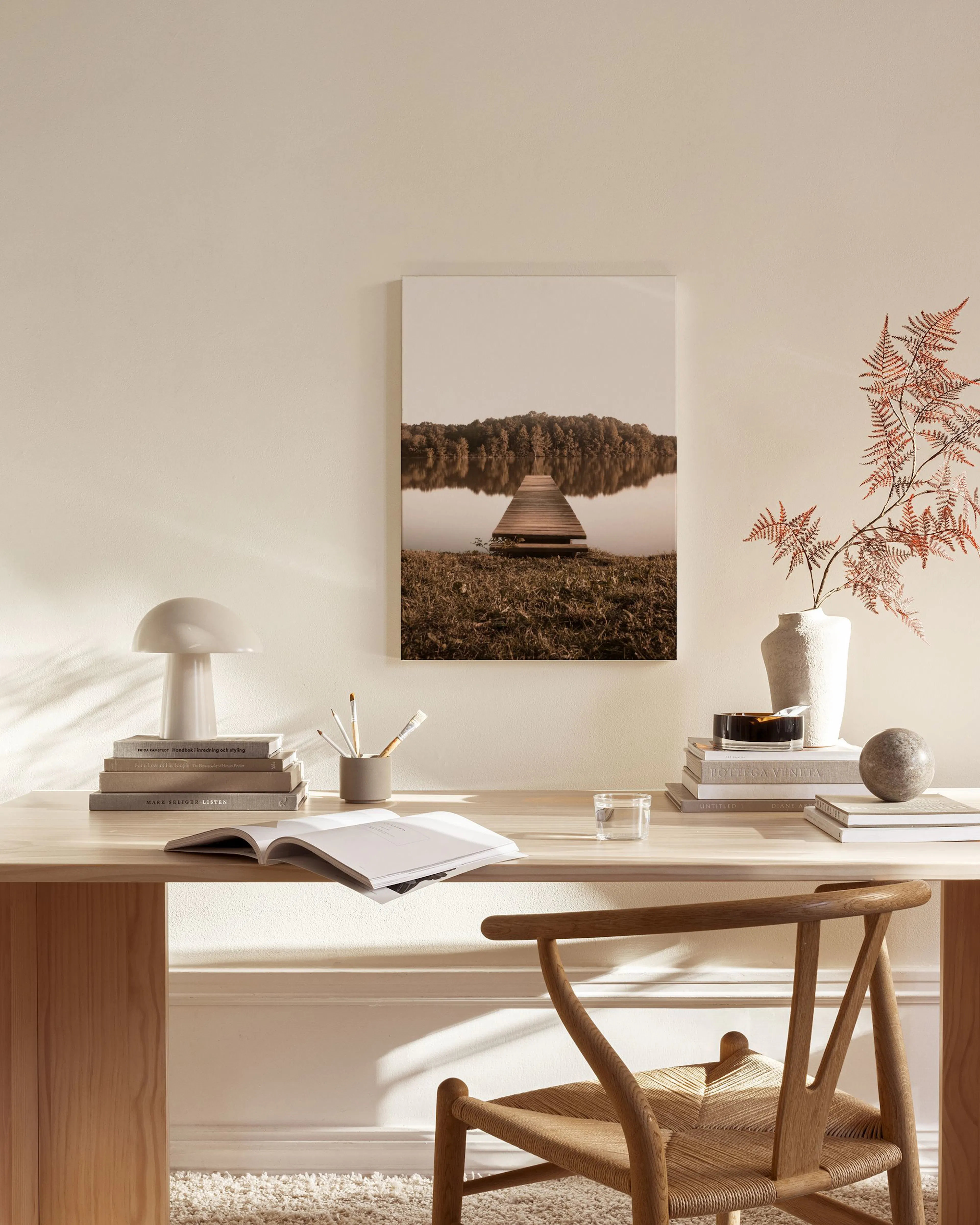 Canvas van een houten steiger over een meer omringd door bomen, hangend in een moderne woonkamer.