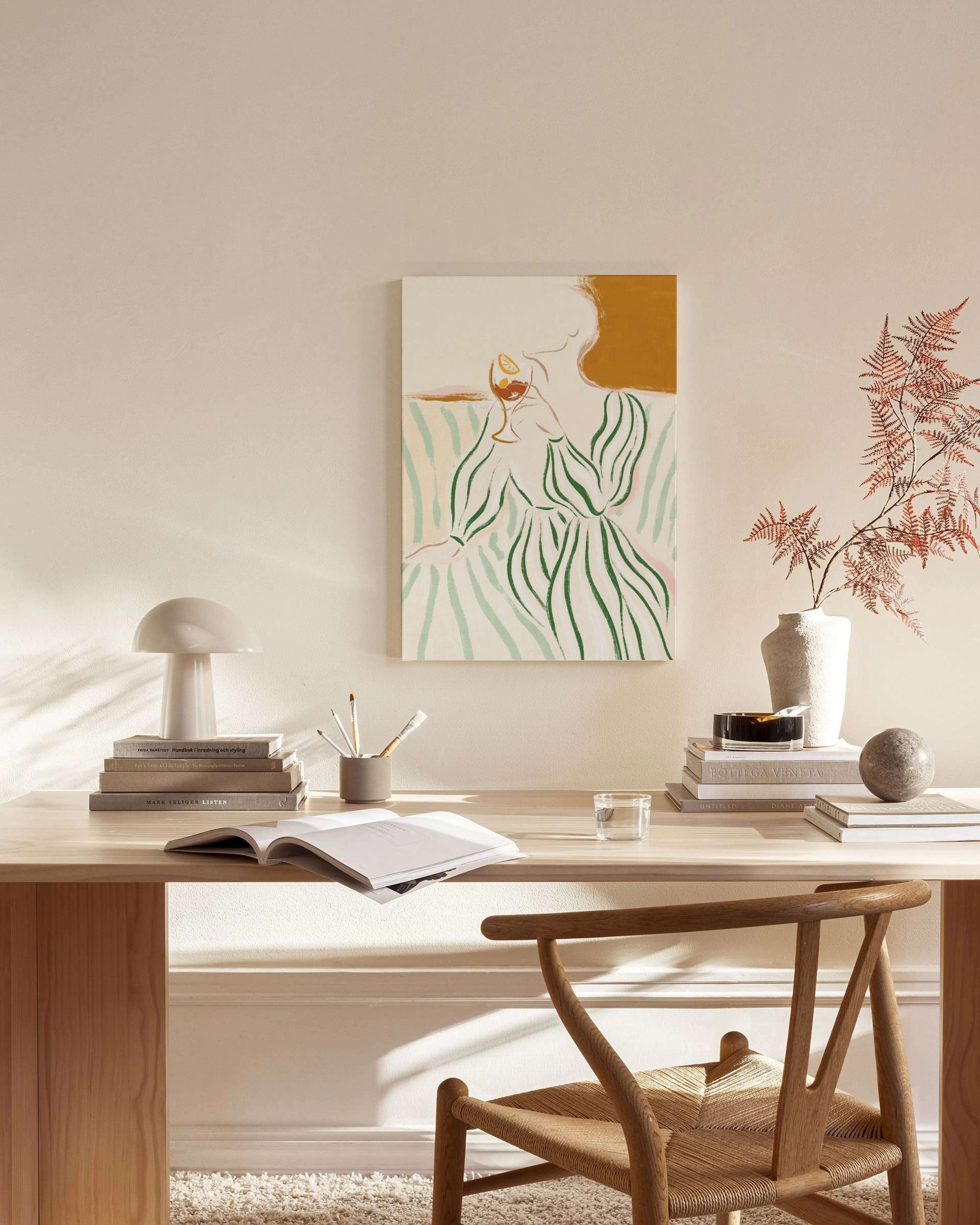 Leinwandbild einer Frau mit gestreiftem Kleid und Weinglas, in einem modernen Wohnzimmer über einem Sideboard.