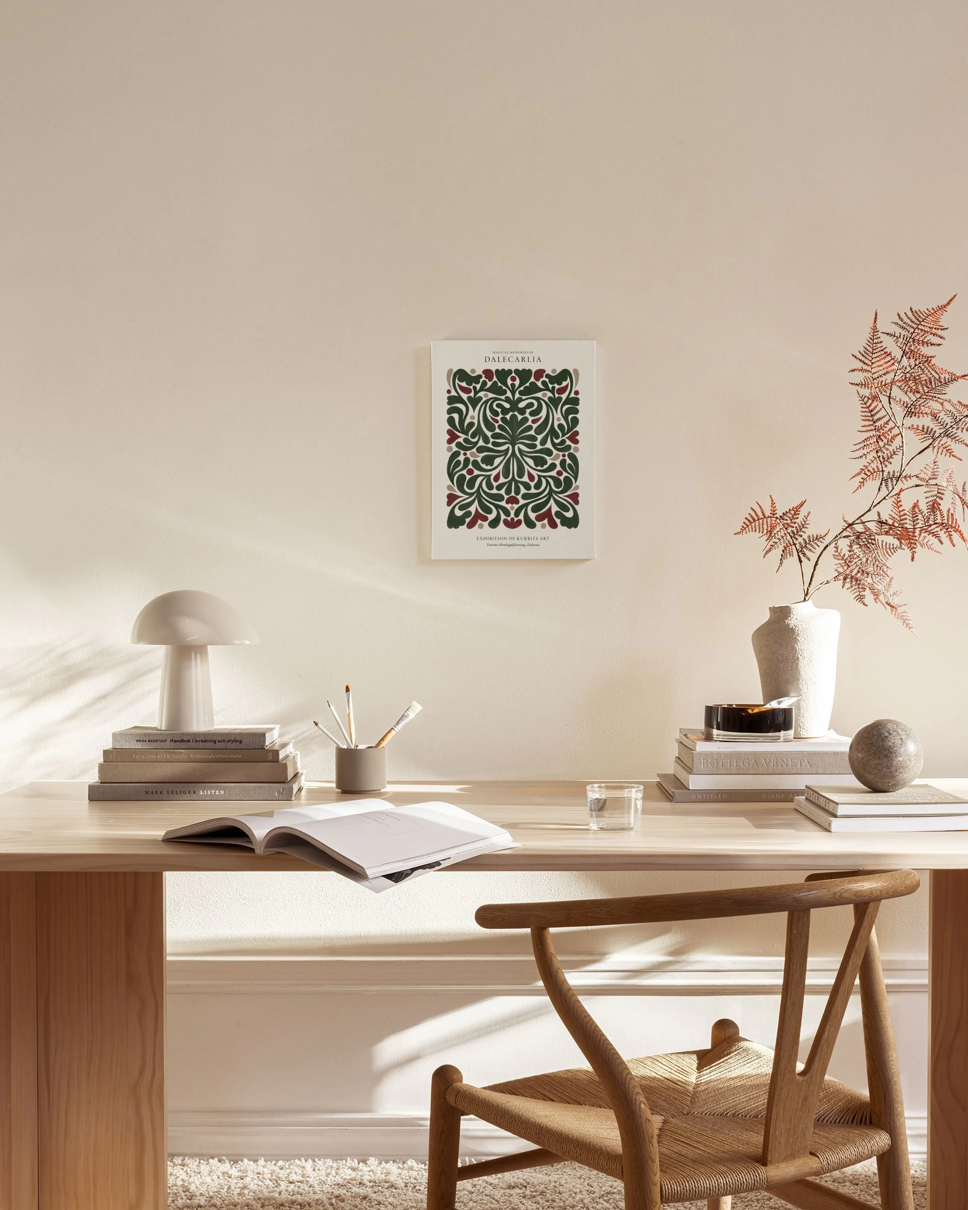 Canvas met donkergroene en bordeauxrode bladeren en bessen, hangend in een lichte woonkamer boven een houten dressoir.