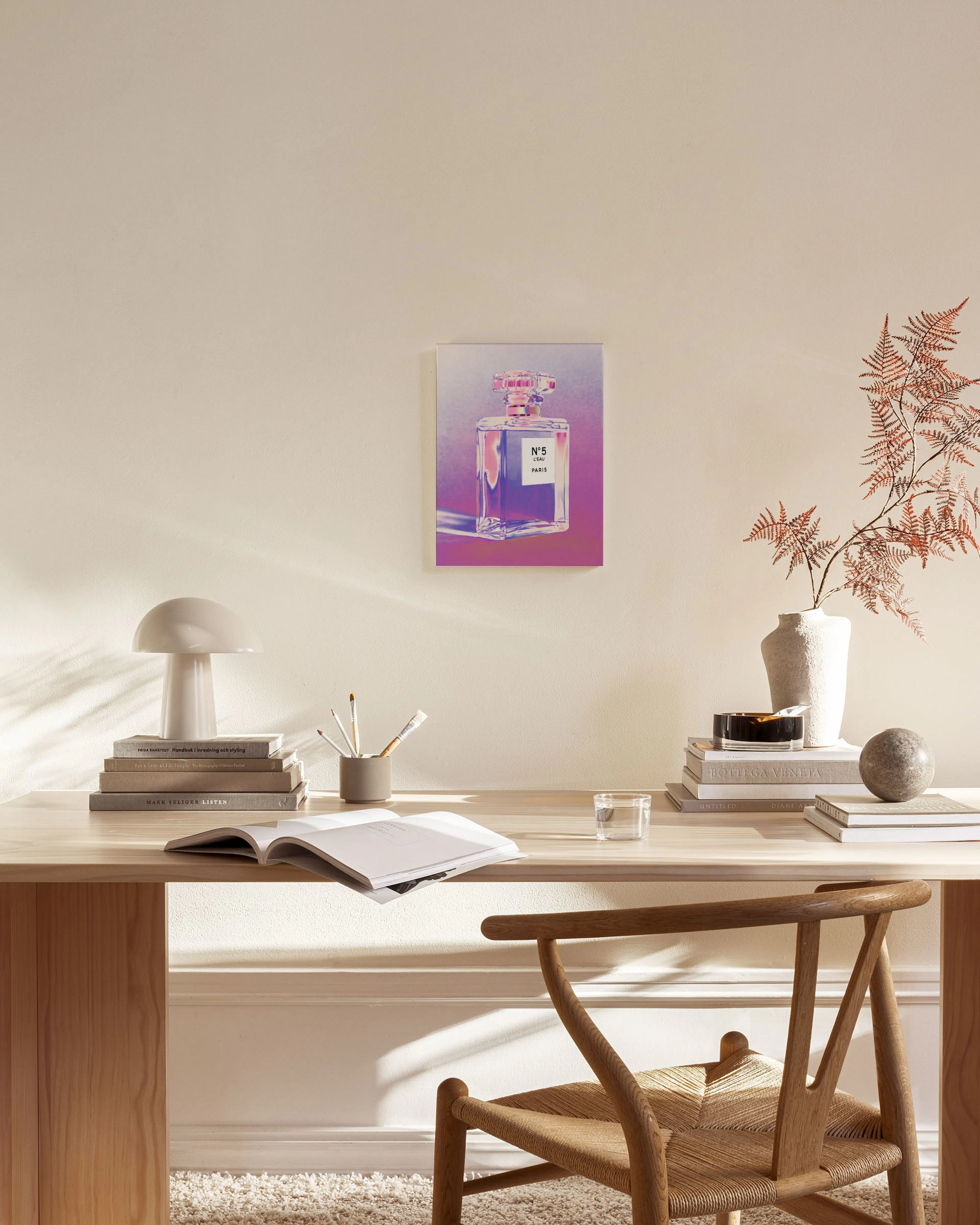 Canvas met een paarse en roze parfumfles, hangend in een neutrale woonkamer boven een houten dressoir.