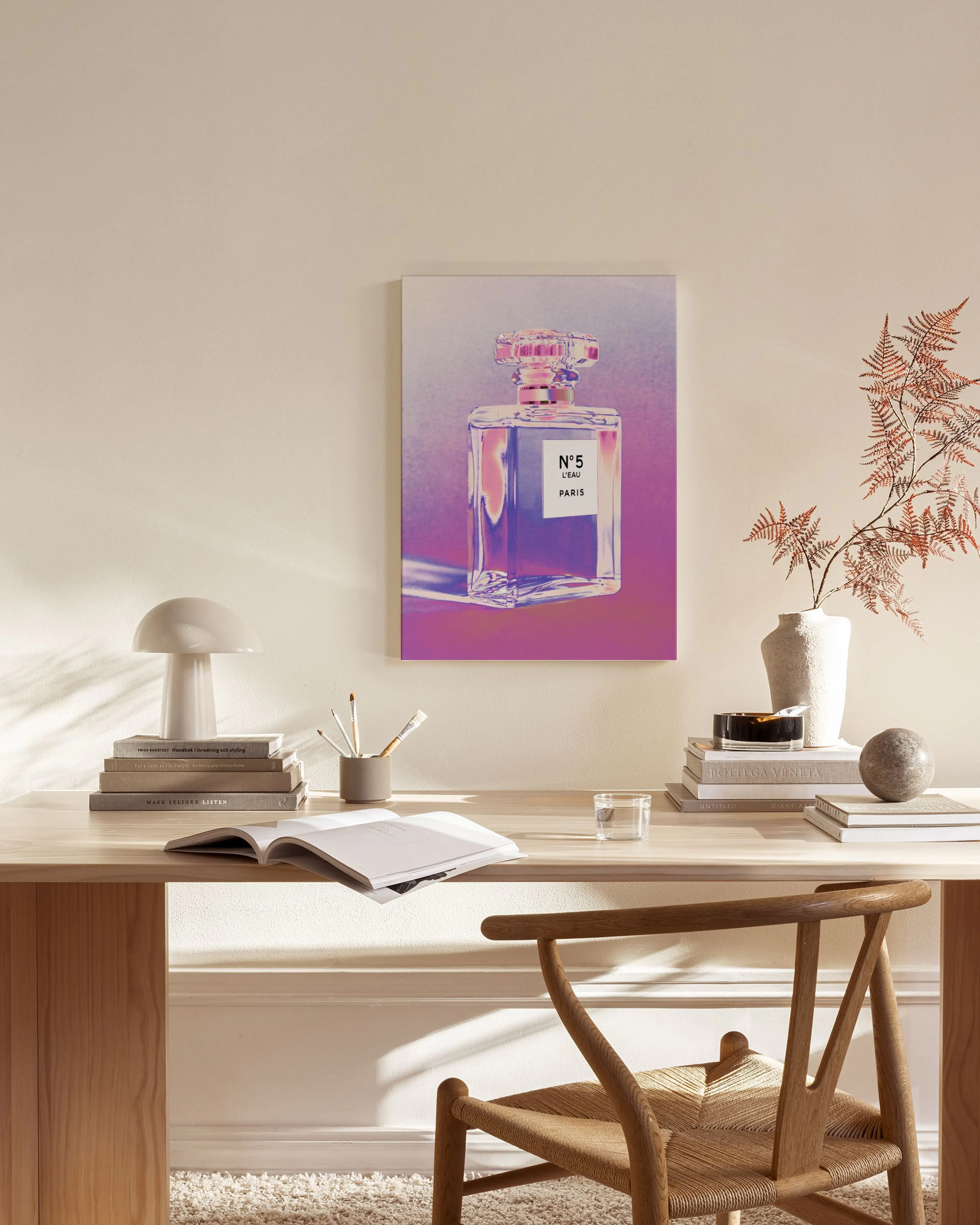 Leinwandbild eines Parfümflakons mit N°5 Schriftzug, in einem modernen Wohnzimmer über einem Sideboard.