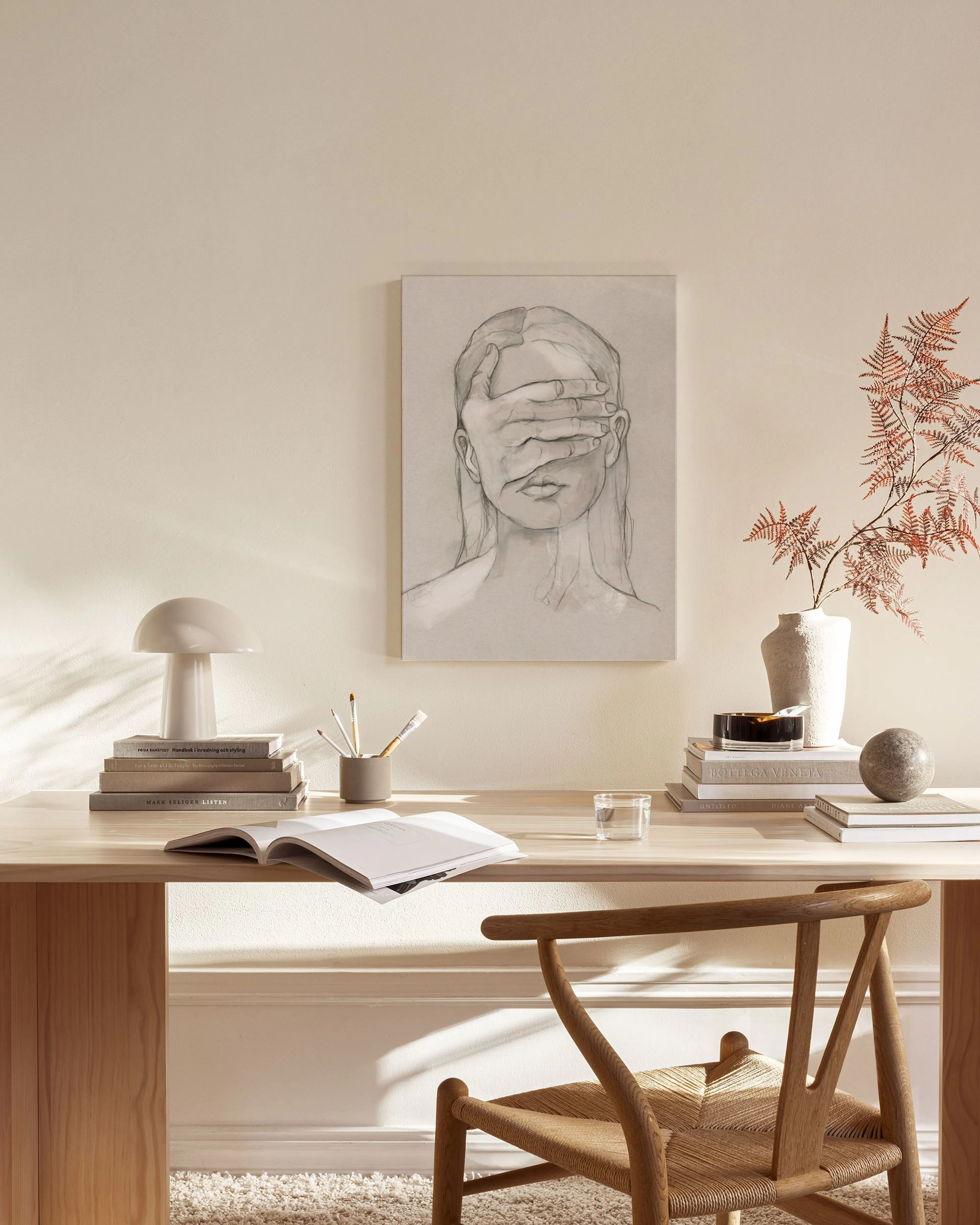 Leinwandbild einer Frau, die sich die Augen verdeckt, in einem minimalistischen Wohnzimmer über einem Sideboard.