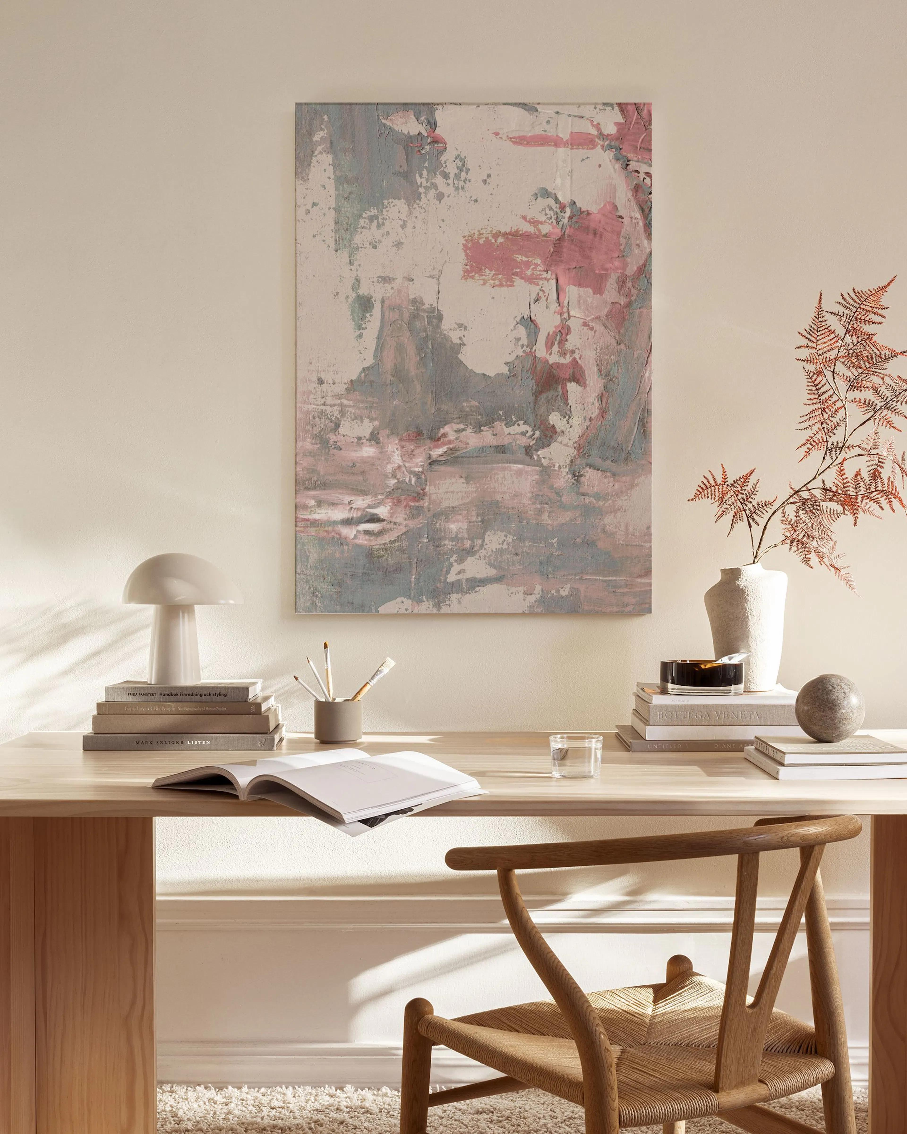 Abstraktes Leinwandbild in Rosa- und Grautönen, über einer Holzkonsole in einem Wohnzimmer.