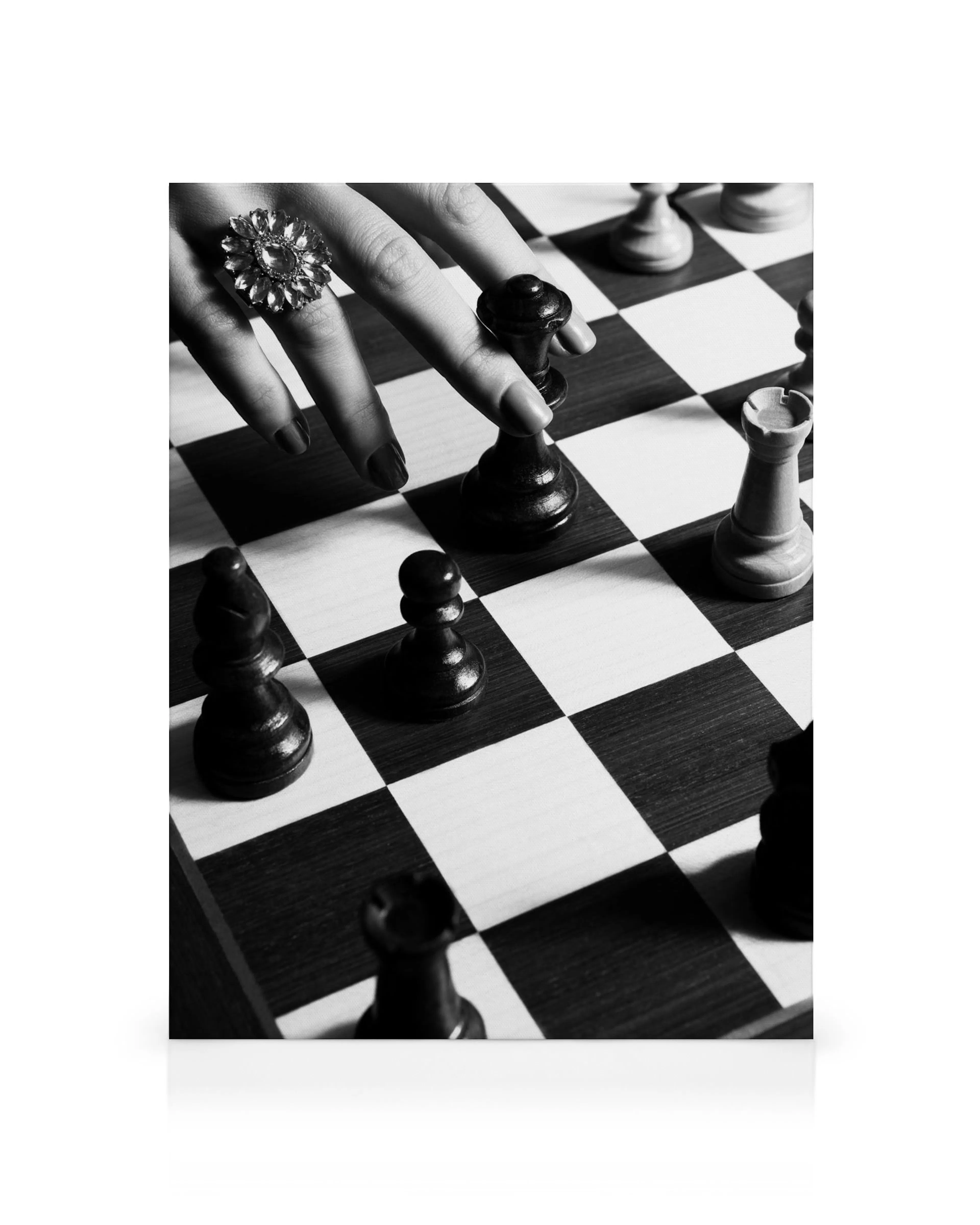 Toile noir et blanc dune main avec bague déplaçant un pion sur un échiquier de jeu déchecs.