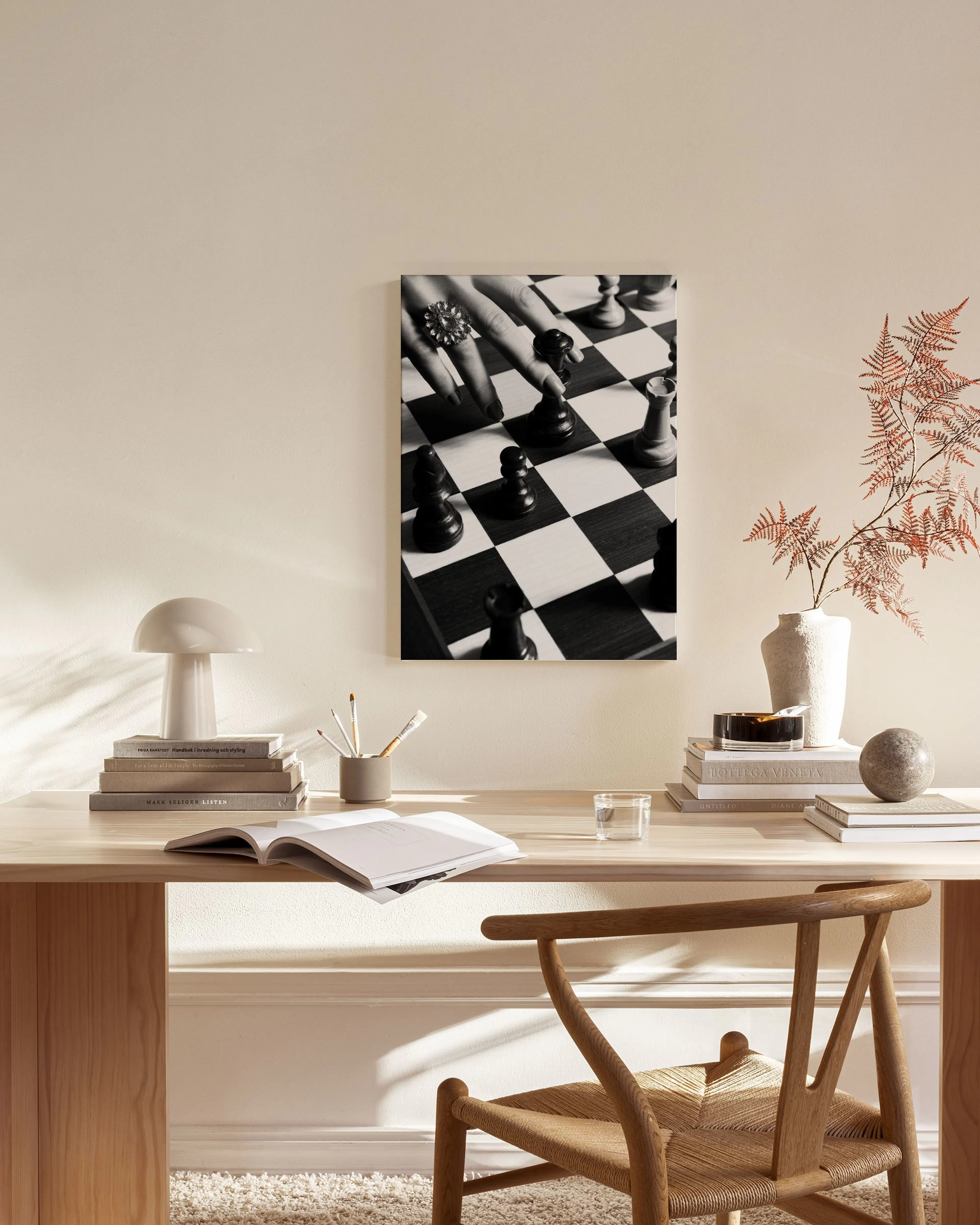 Schwarz-weiß Leinwandbild mit einer Hand, die eine Schachfigur bewegt, in einem modernen Wohnzimmer.