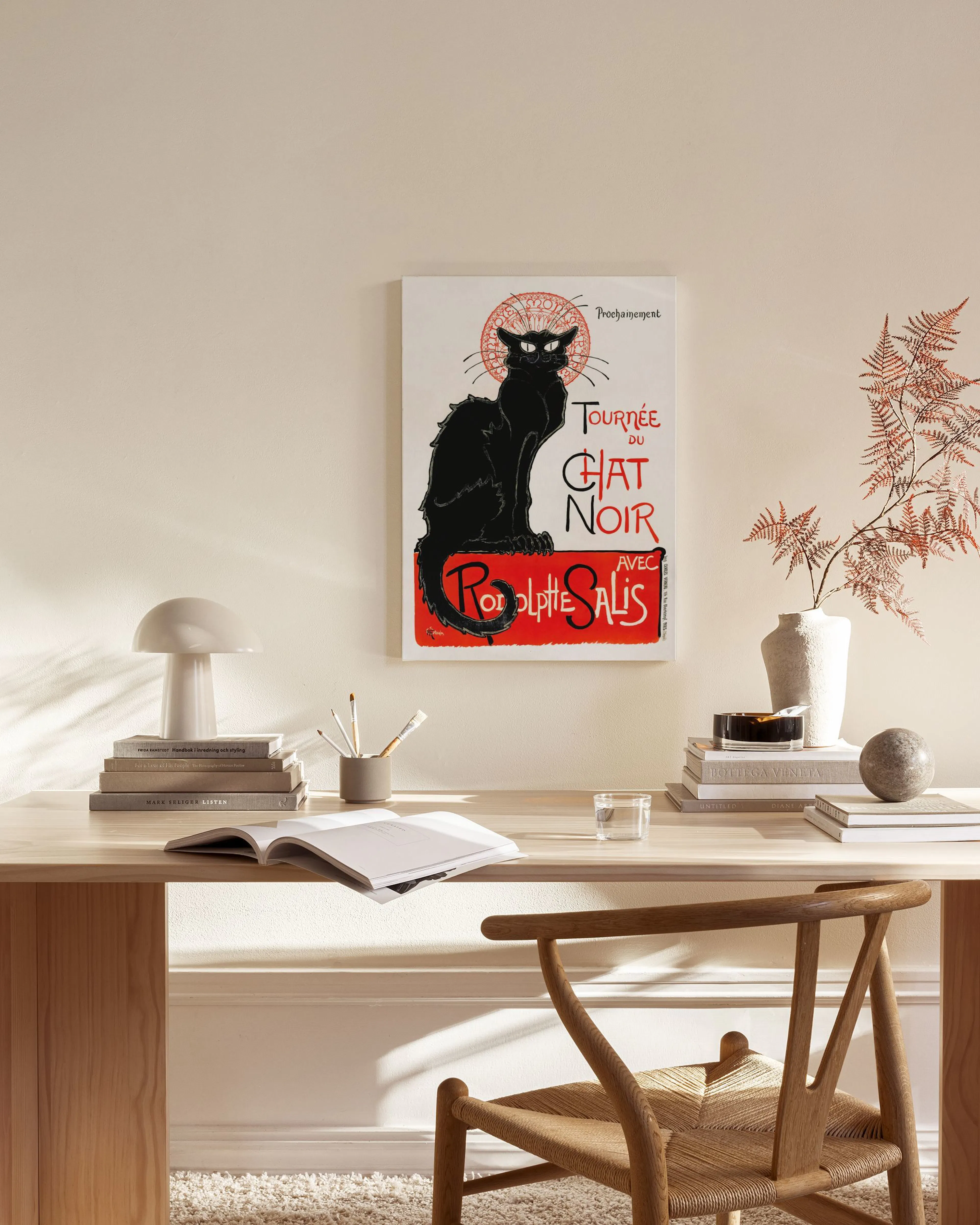 Leinwandbild: Schwarze Katze mit roten Augen und rotem Schriftzug, hängend über einem Sideboard in einem hellen Wohnzimmer.