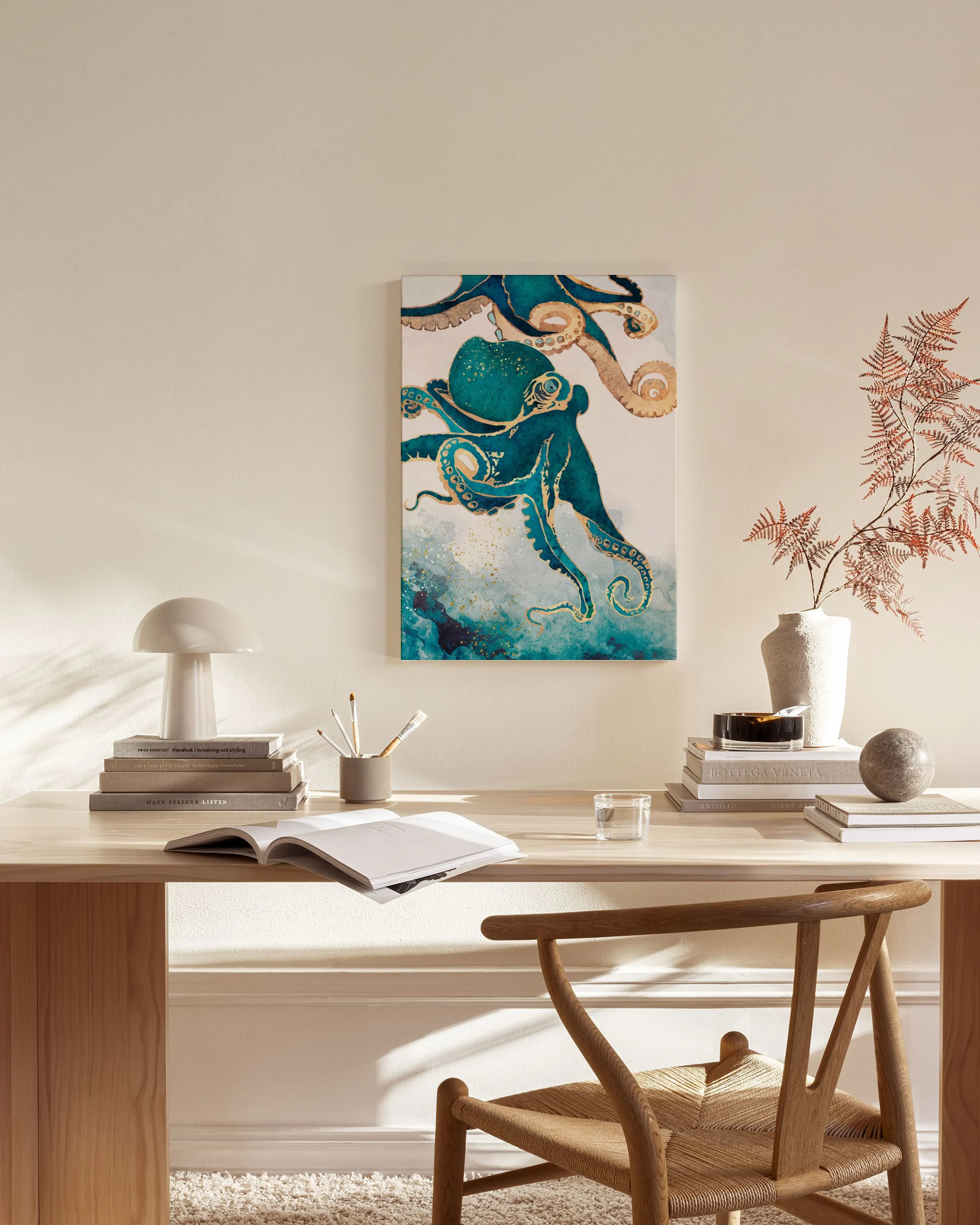 Leinwandbild mit türkisfarbenem Kraken und goldenen Akzenten, an einer hellen Wand über einem Sideboard im Wohnzimmer.