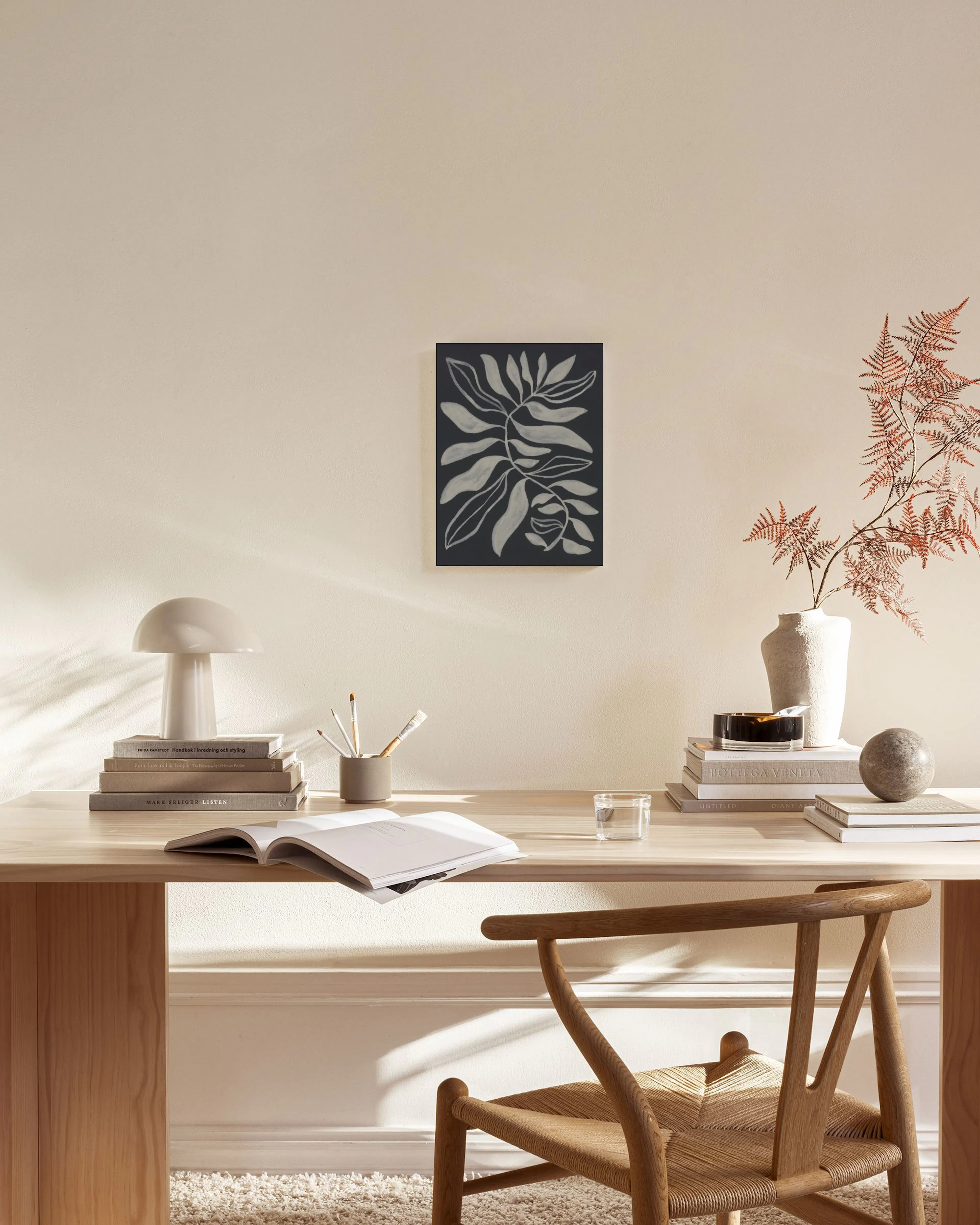 Botanische print op canvas met witte bladeren en takken op een donkergrijze achtergrond.