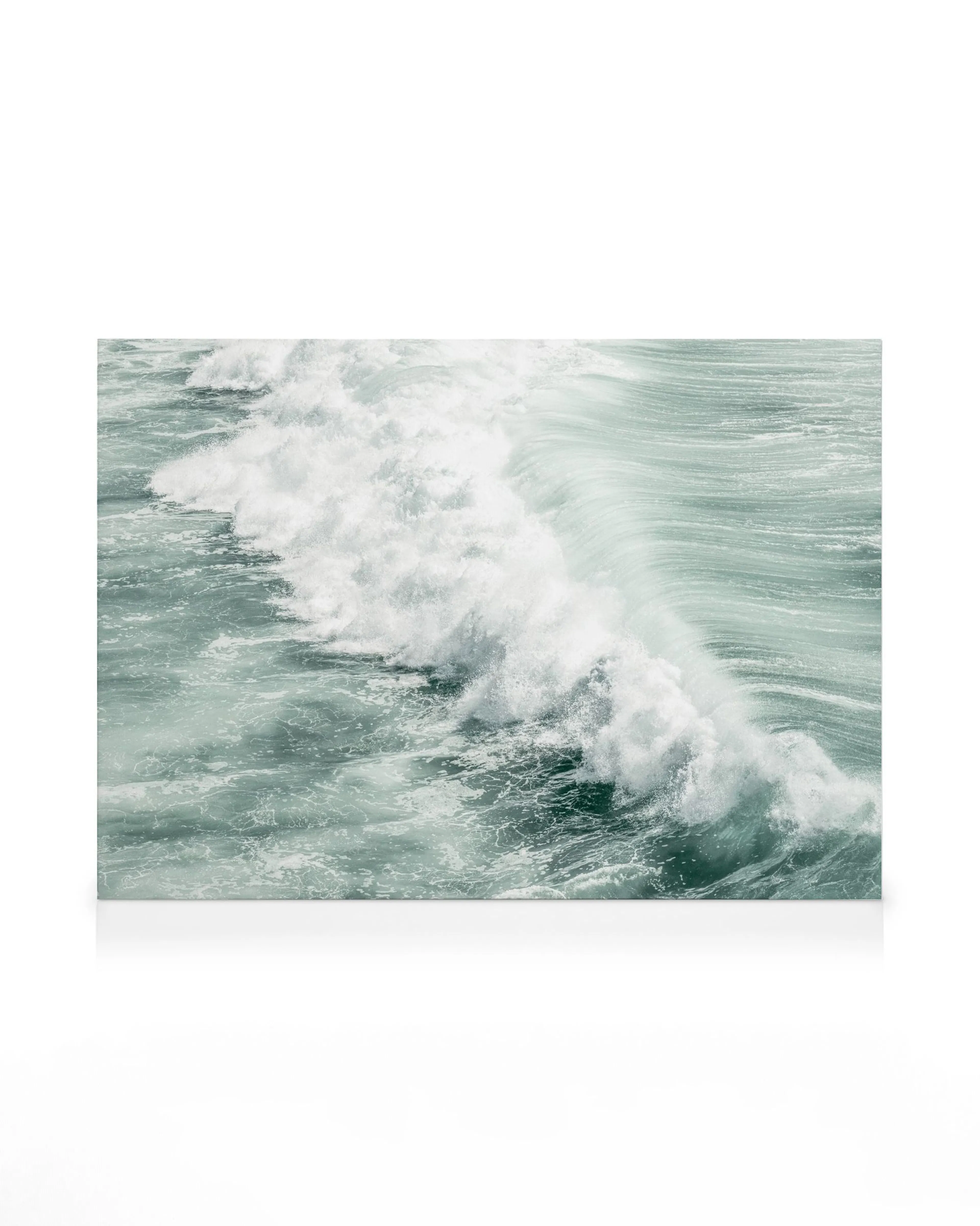 Turquoise ocean wave breaking, with white spray and foam on a calm sea surface.
