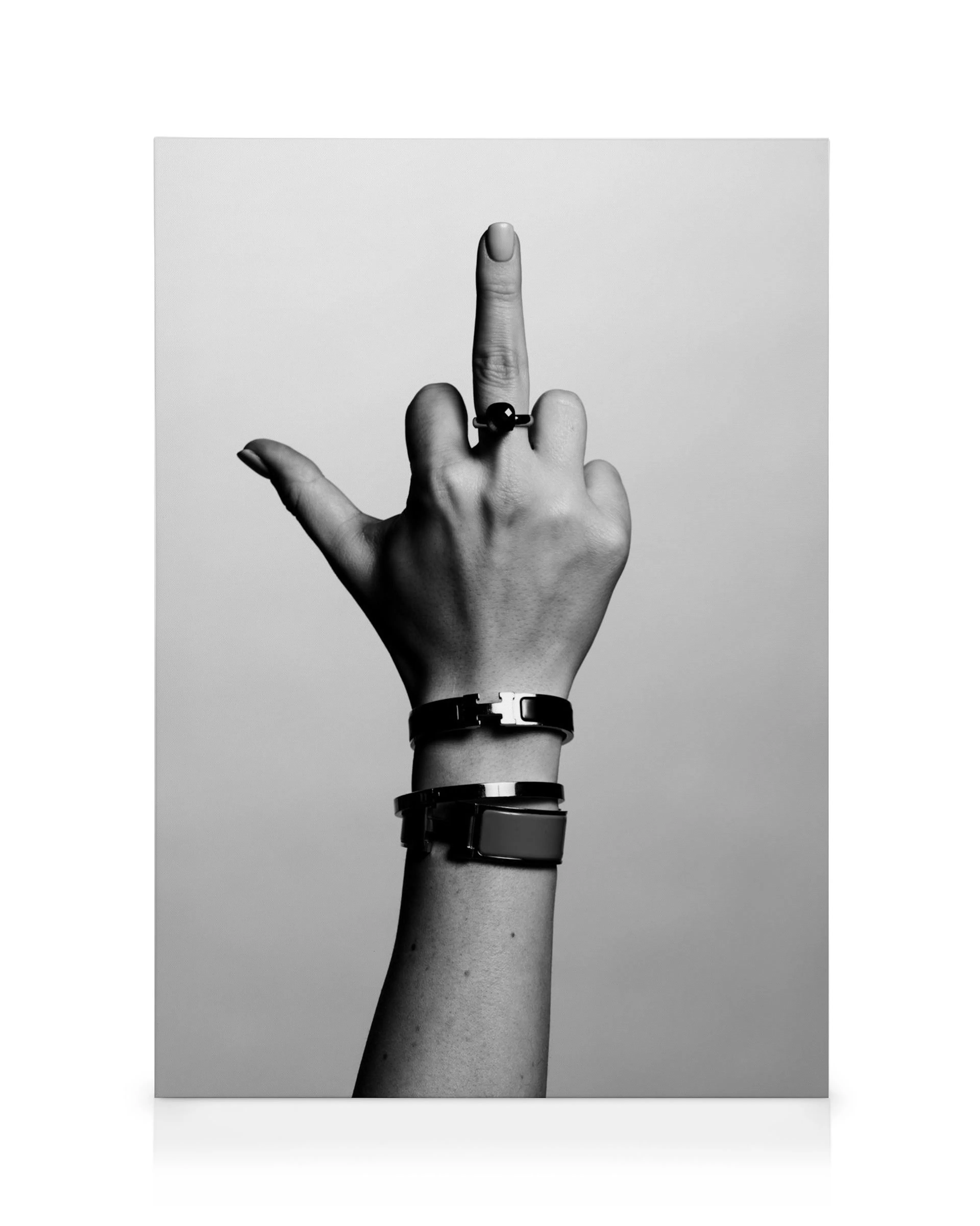 Black and white canvas print of a hand wearing bracelets and a ring, with the middle finger extended in an expressive gesture.