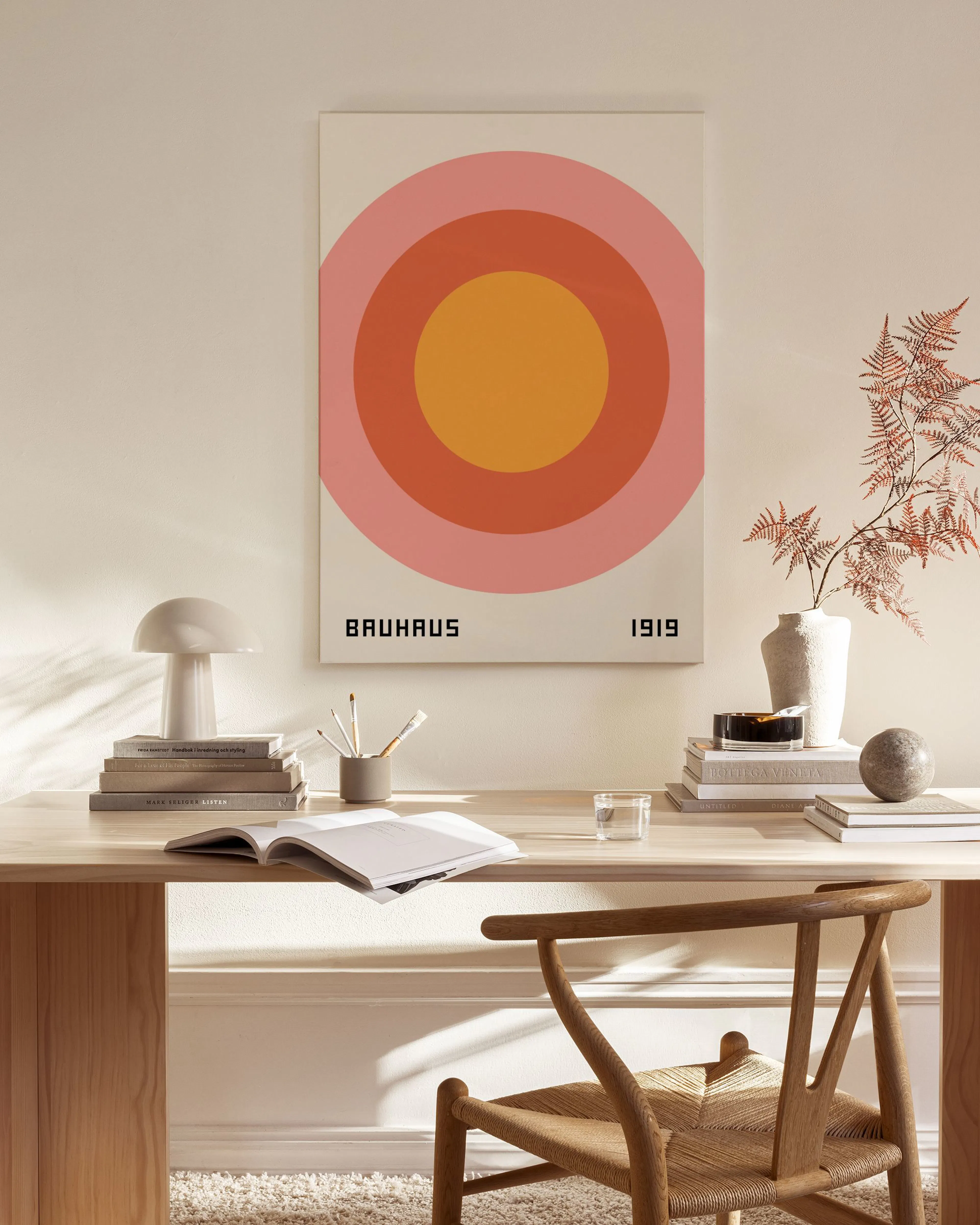 Toile Bauhaus géométrique avec cercles concentriques rose, orange et jaune, affichée dans un salon moderne.