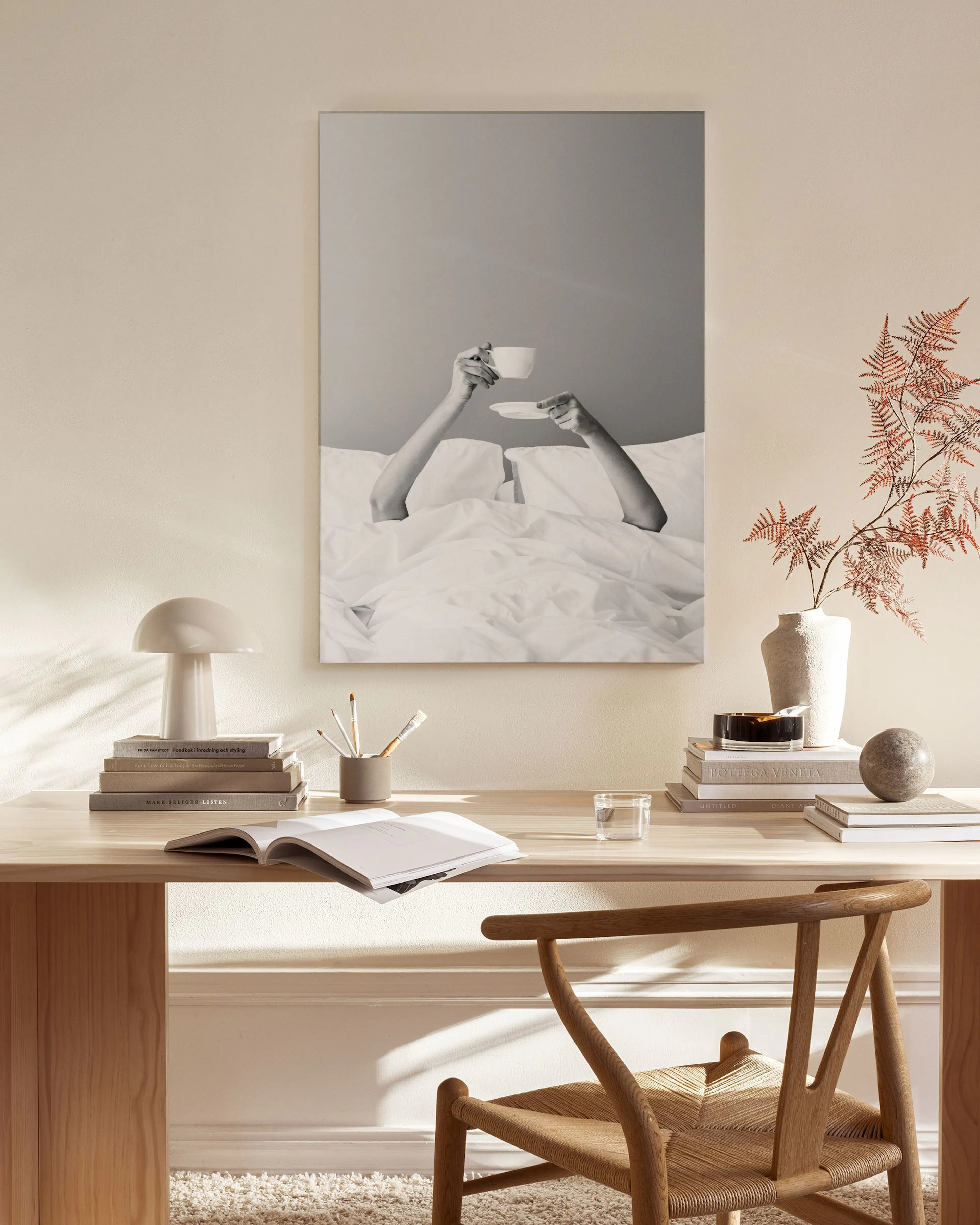 Schwarz-weißes Leinwandbild mit Händen und Kaffeetasse, aufgehängt in einem modernen Wohnzimmer über einem Sideboard.