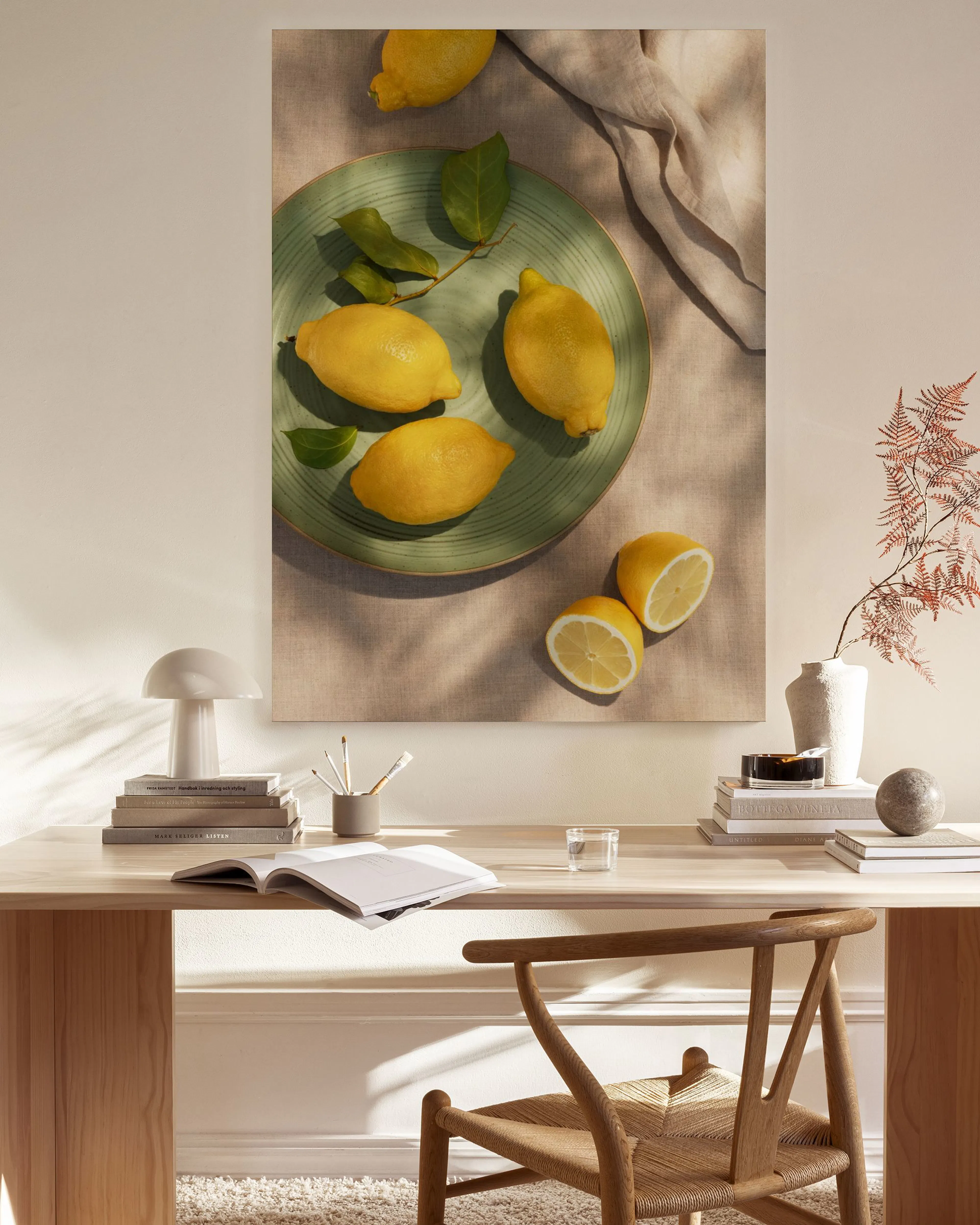 Lienzo con bodegón de limones amarillos frescos en un plato verde y sobre un paño de lino beige, con sombras sutiles.