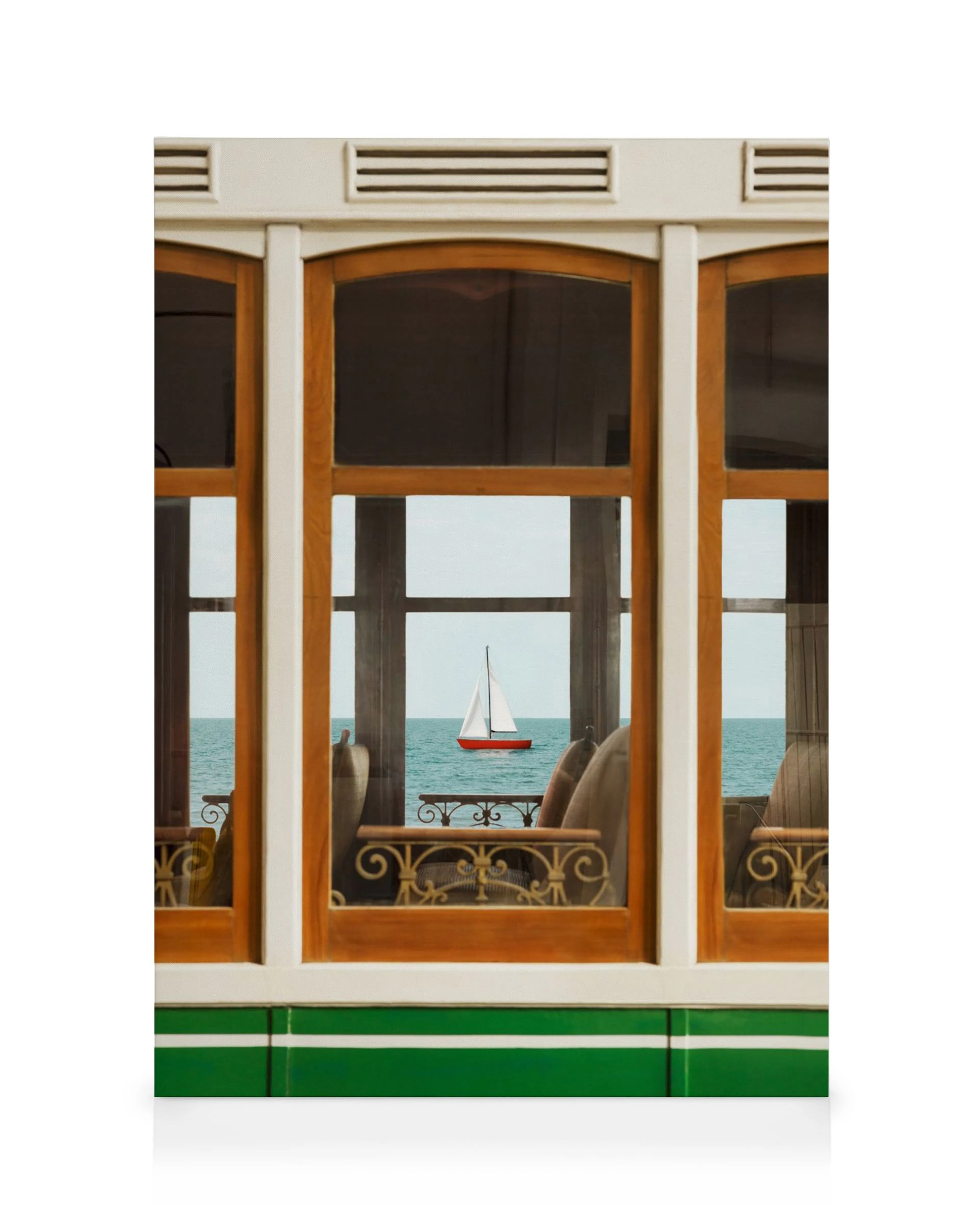 Leinwandbild einer roten Segelyacht auf blauem Meer, durch ein Holzfenster mit hellgrünem Rahmen gesehen.