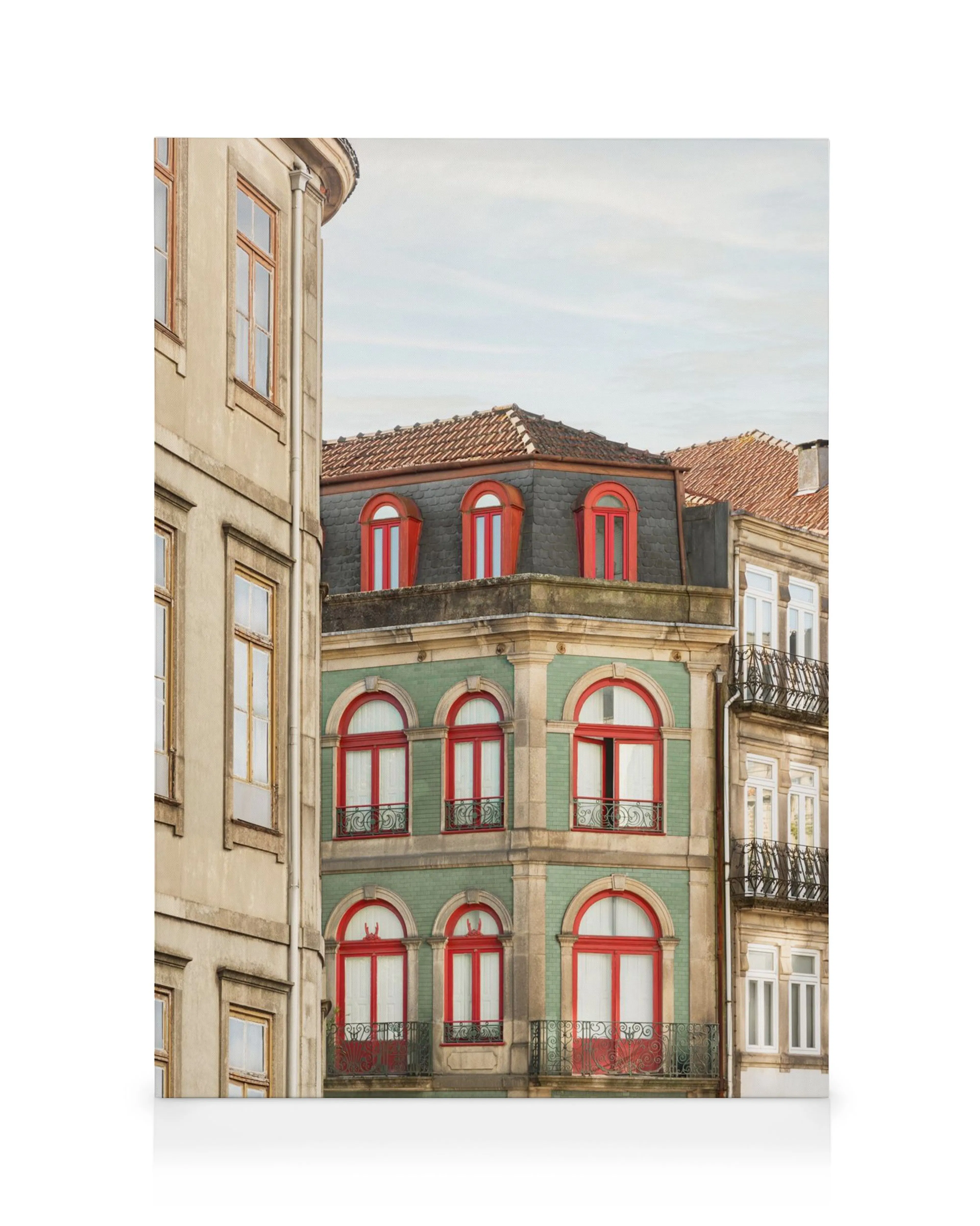 A canvas print showcasing a historic green building with red-framed arched windows and an adjacent beige building.
