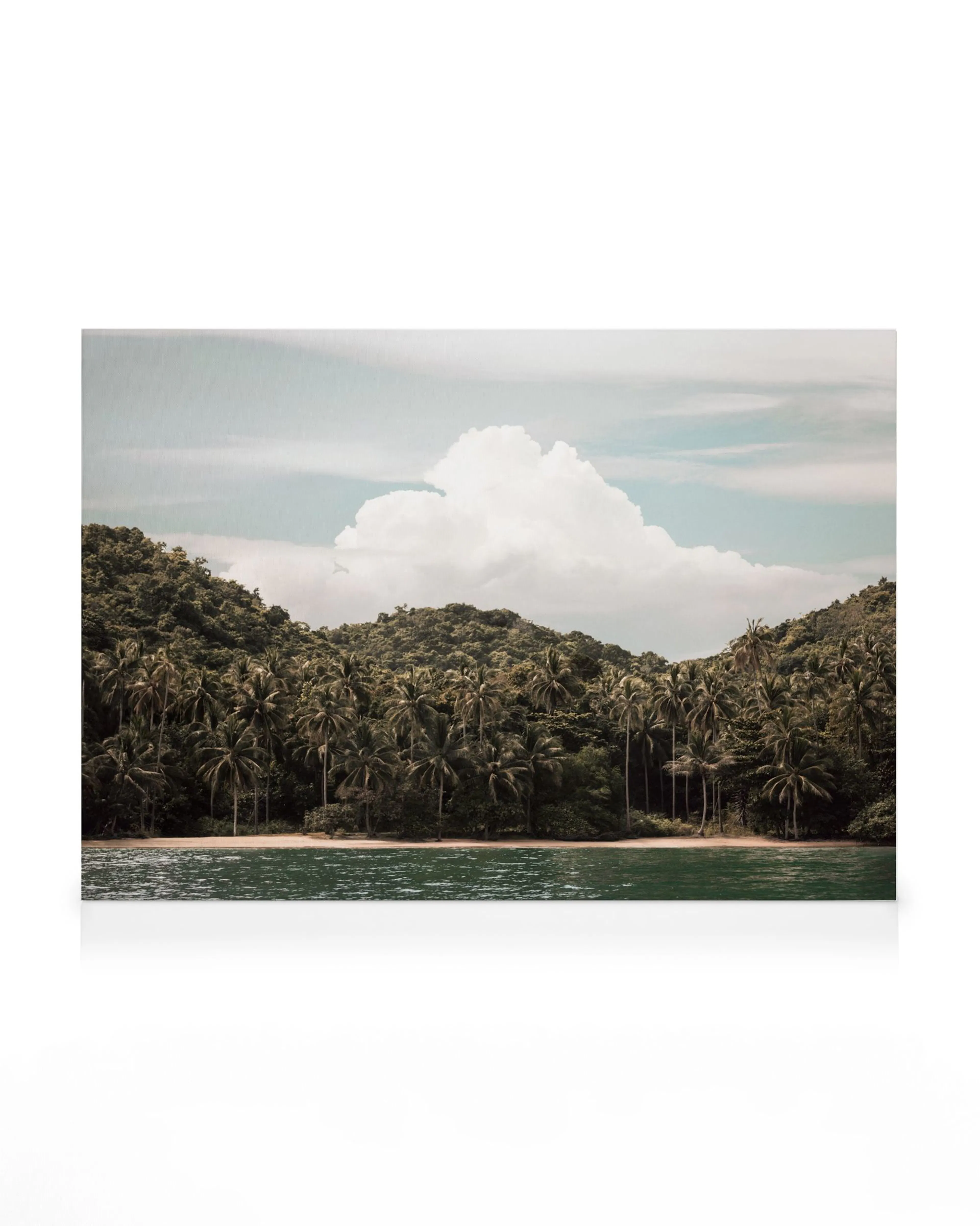 A canvas print of a tropical island landscape with lush green hills, palm trees, a sandy beach, and calm turquoise water.
