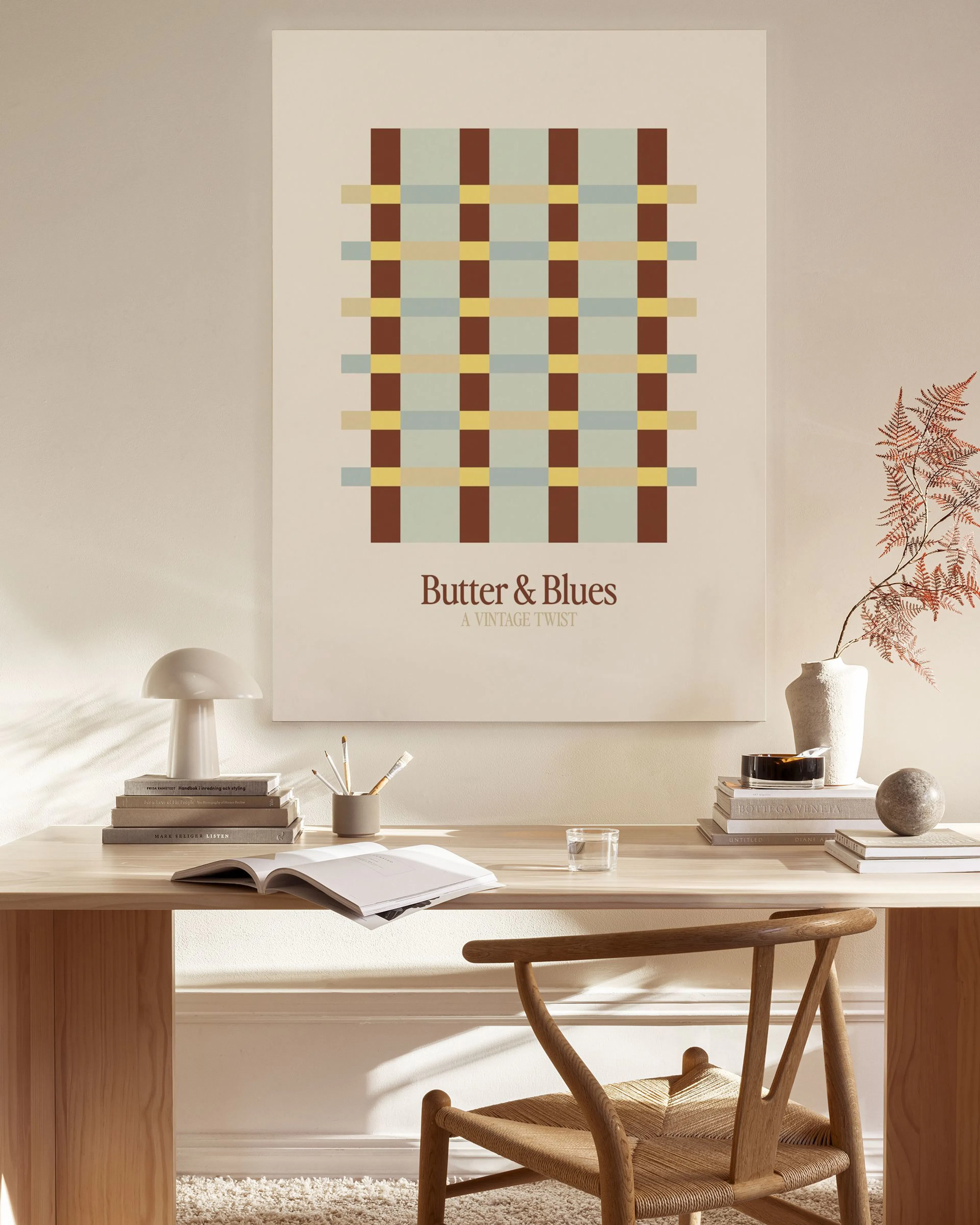 Lienzo con patrón de cuadros en tonos burdeos, beige y azul claro, sobre pared lisa en un salón moderno.