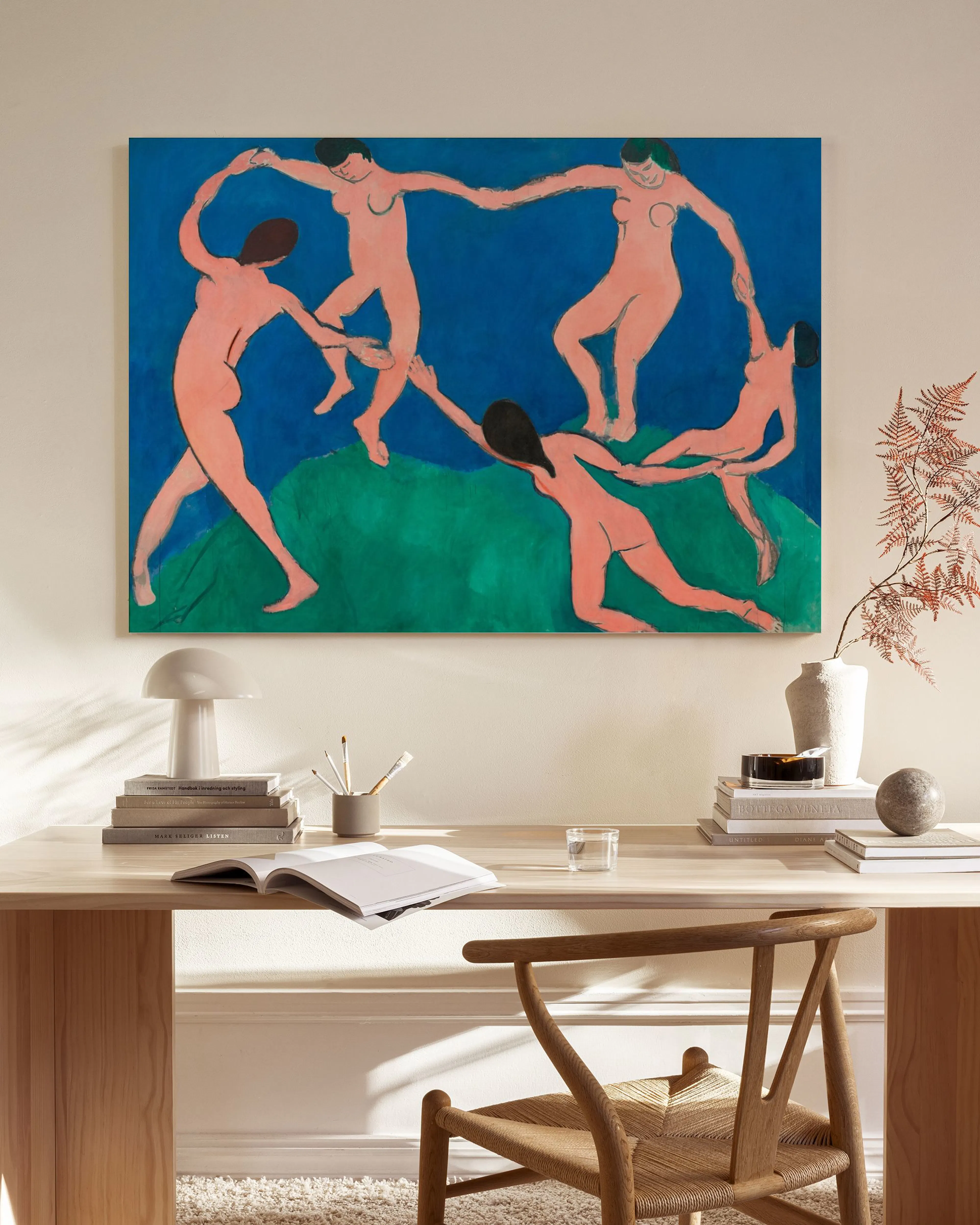Obraz na plátně s tancujícími postavami ve stylu Henriho Matisse, visící v moderním obývacím pokoji nad dřevěnou komodou.