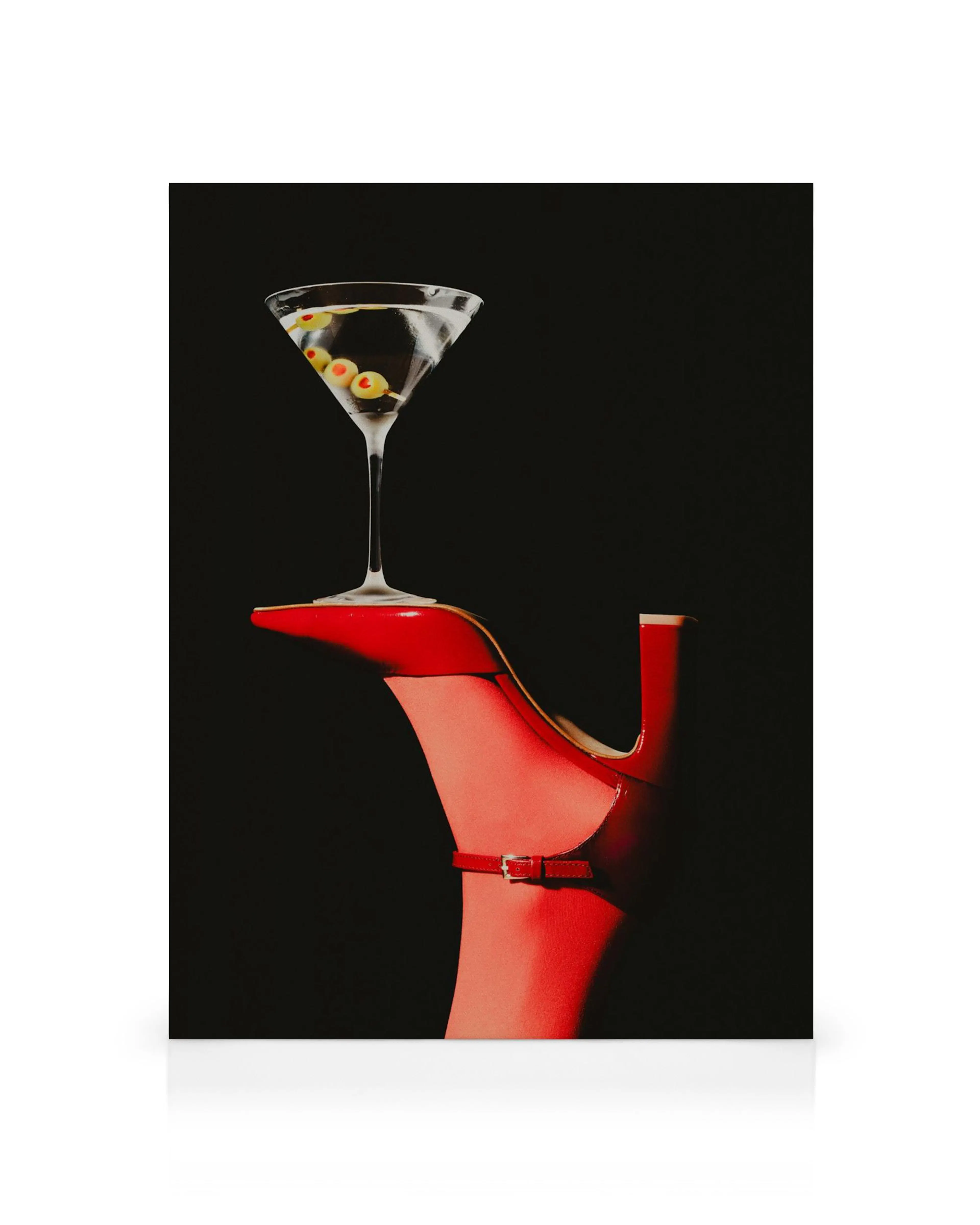 Red high heel balances a martini glass with olives, a unique canvas print.